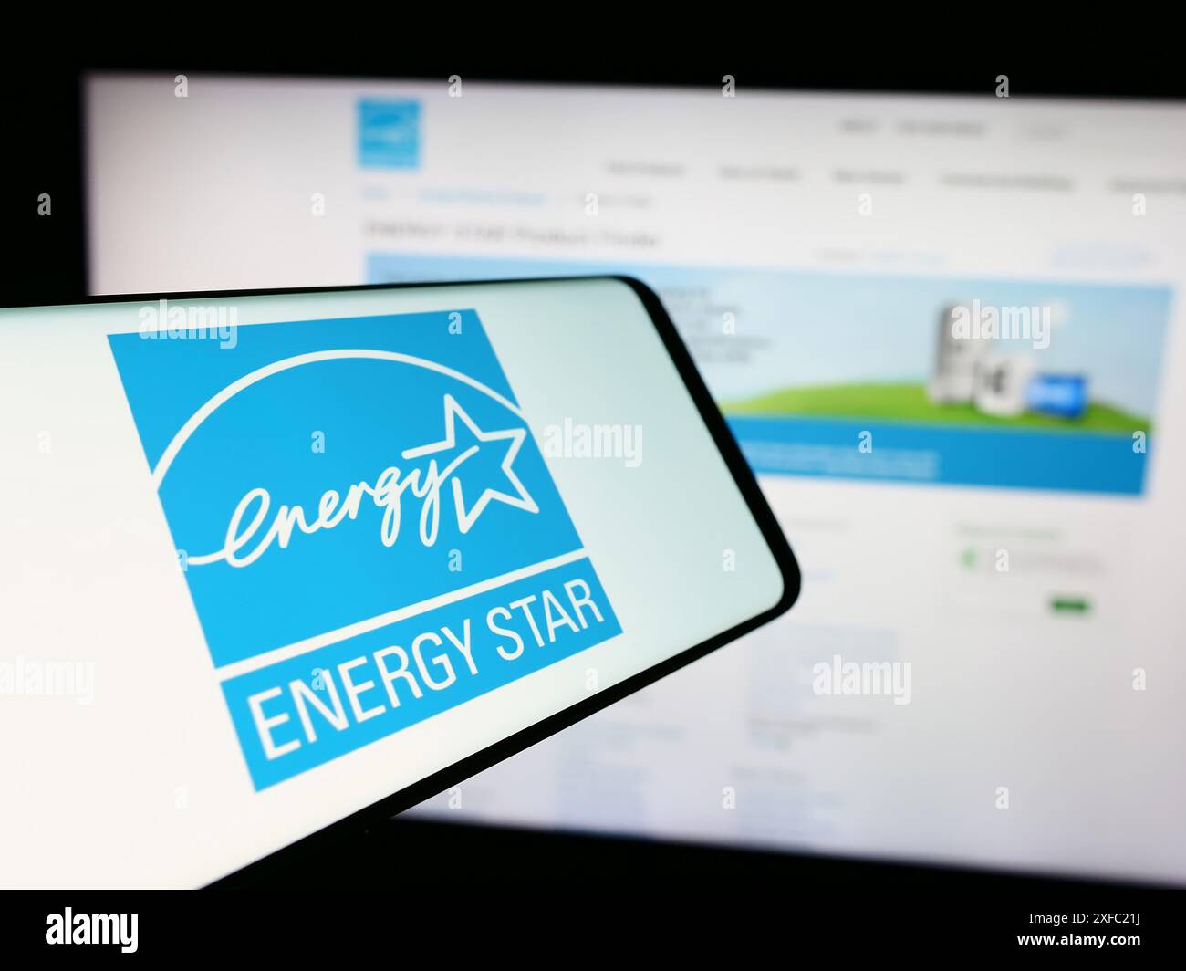 Cellulare con logo del programma americano di efficienza energetica Energy Star davanti al sito web. Messa a fuoco al centro del display del telefono. Foto Stock