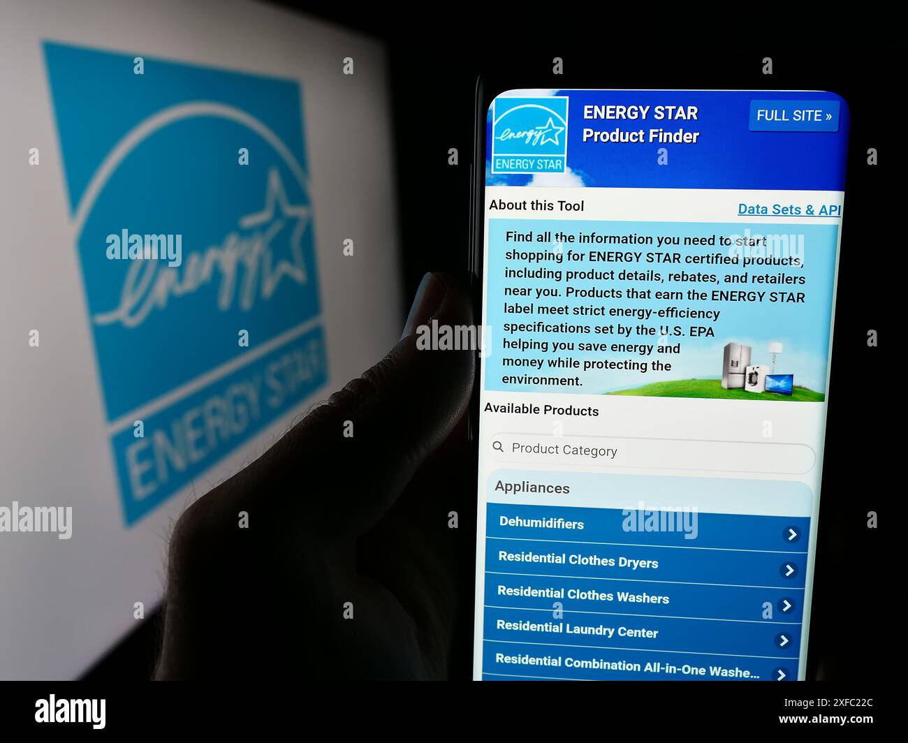 Persona che possiede uno smartphone con la pagina Web del programma di efficienza energetica degli Stati Uniti Energy Star davanti al logo. Messa a fuoco al centro del display del telefono. Foto Stock