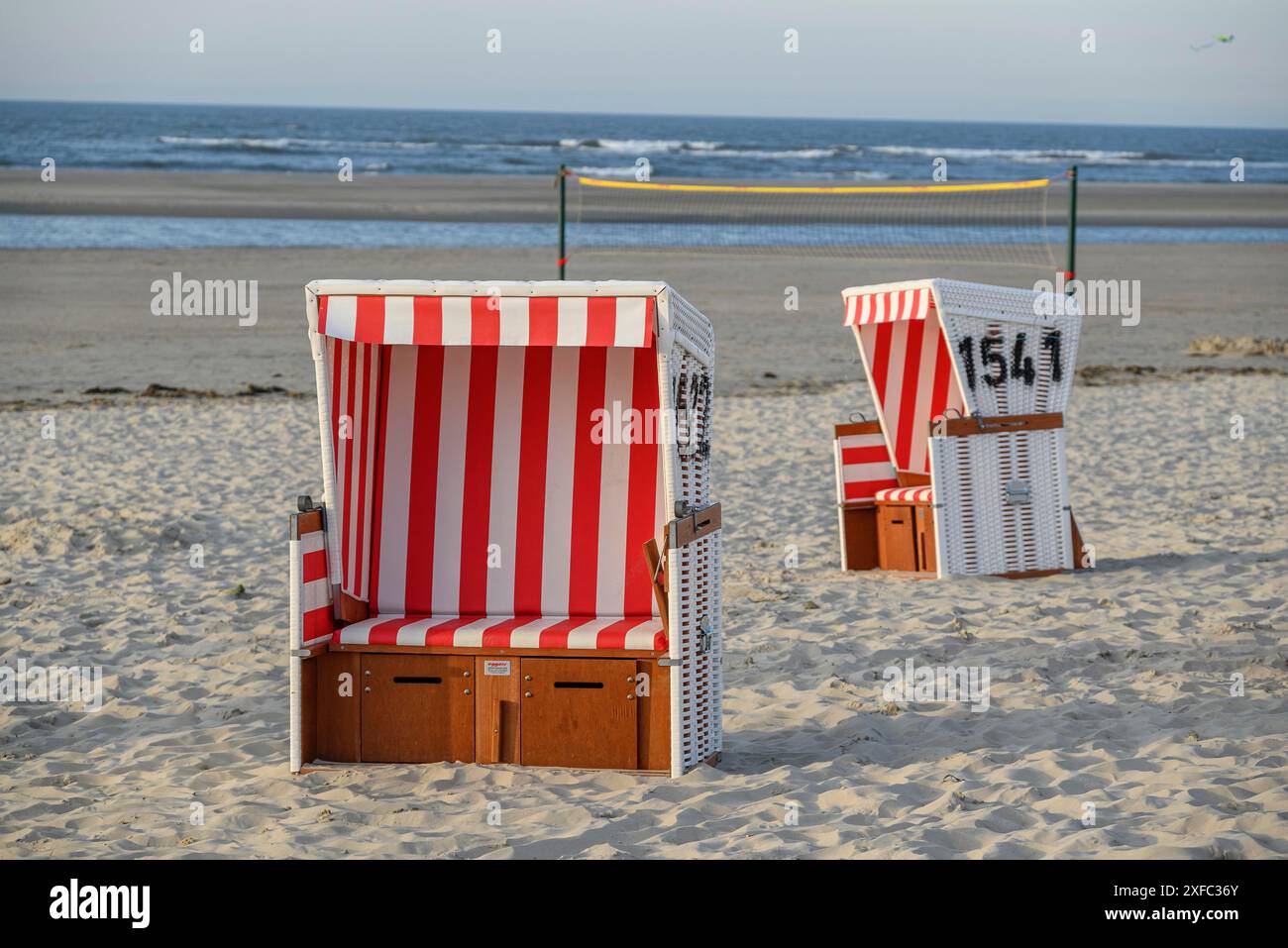 Due sdraio a righe rosse e bianche si trovano sulla spiaggia sabbiosa con vista sul mare, langeoog, frisia orientale, germania Foto Stock