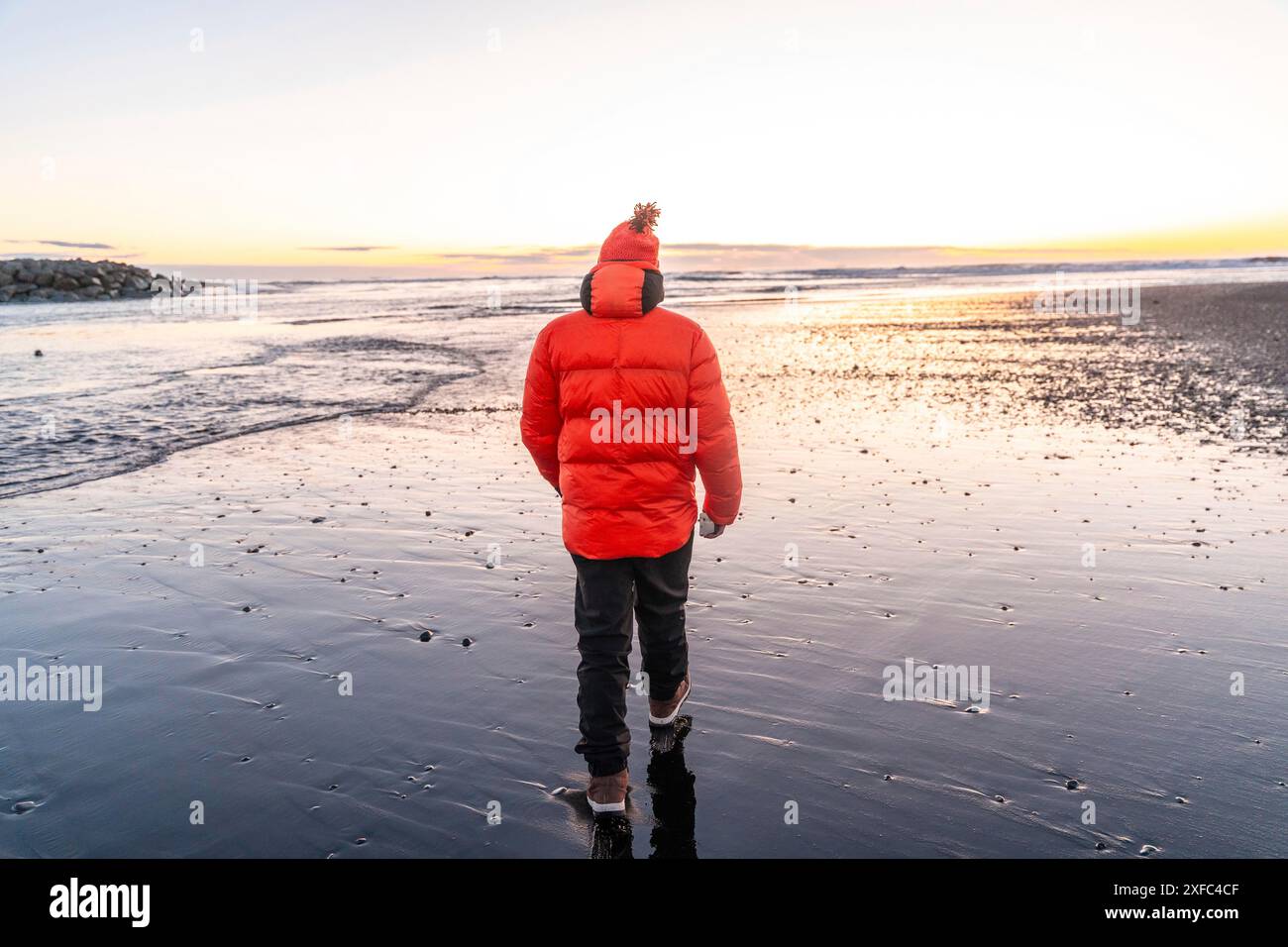 Un uomo che passeggiava all'alba su Diamond Beach Islanda in inverno Foto Stock