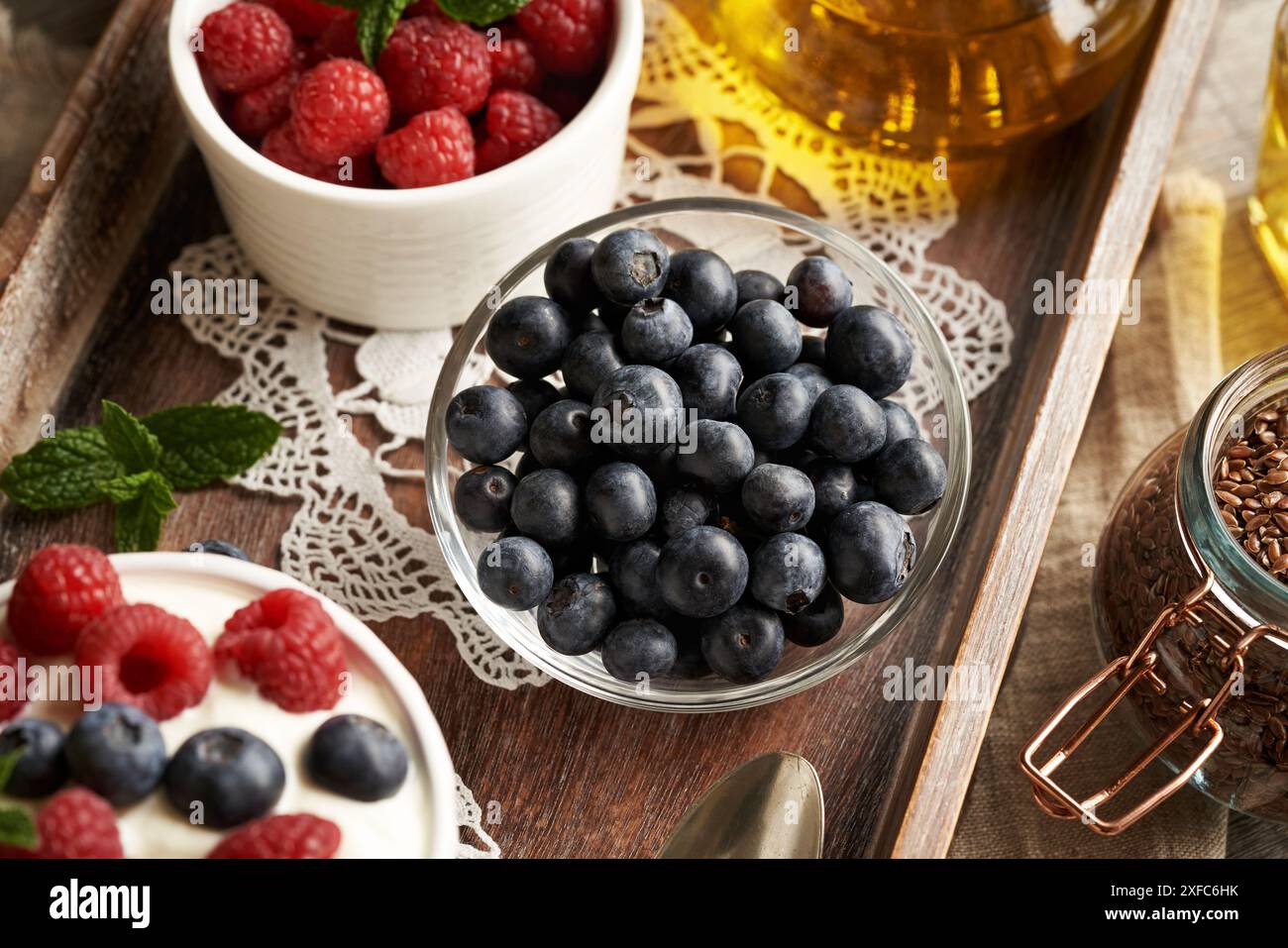 Mirtilli freschi in una ciotola, con semi di lino, lamponi e formaggio fresco in forno Foto Stock Mirtilli freschi in una ciotola, con semi di lino, lamponi e formaggio fresco in forno Foto Stock
