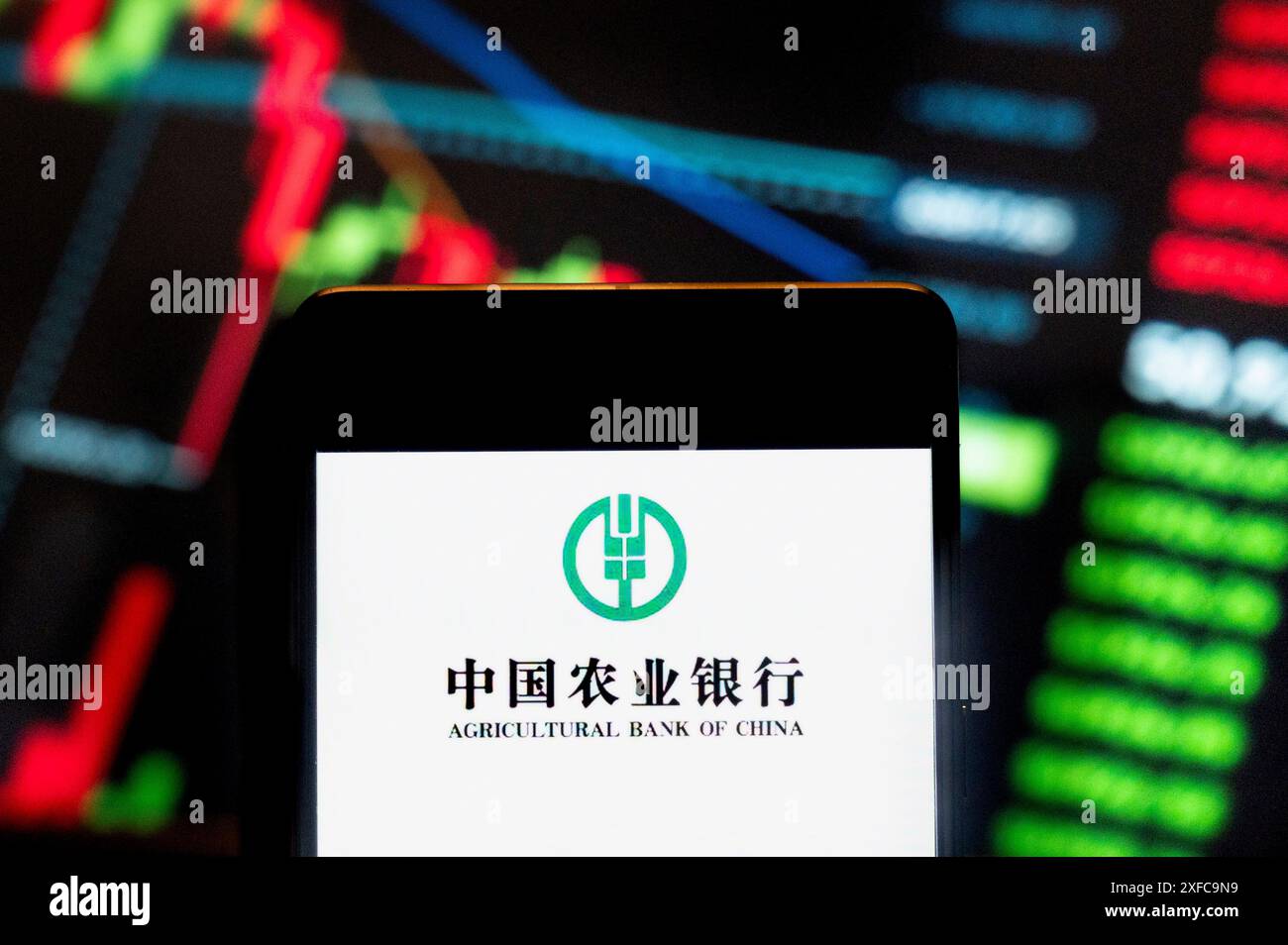Cina. 21 giugno 2024. In questa illustrazione fotografica, il logo della società bancaria cinese Agricultural Bank of China visualizzato su uno smartphone con un grafico dell'indice di borsa economica sullo sfondo. (Credit Image: © Budrul Chukrut/SOPA Images via ZUMA Press Wire) SOLO PER USO EDITORIALE! Non per USO commerciale! Foto Stock