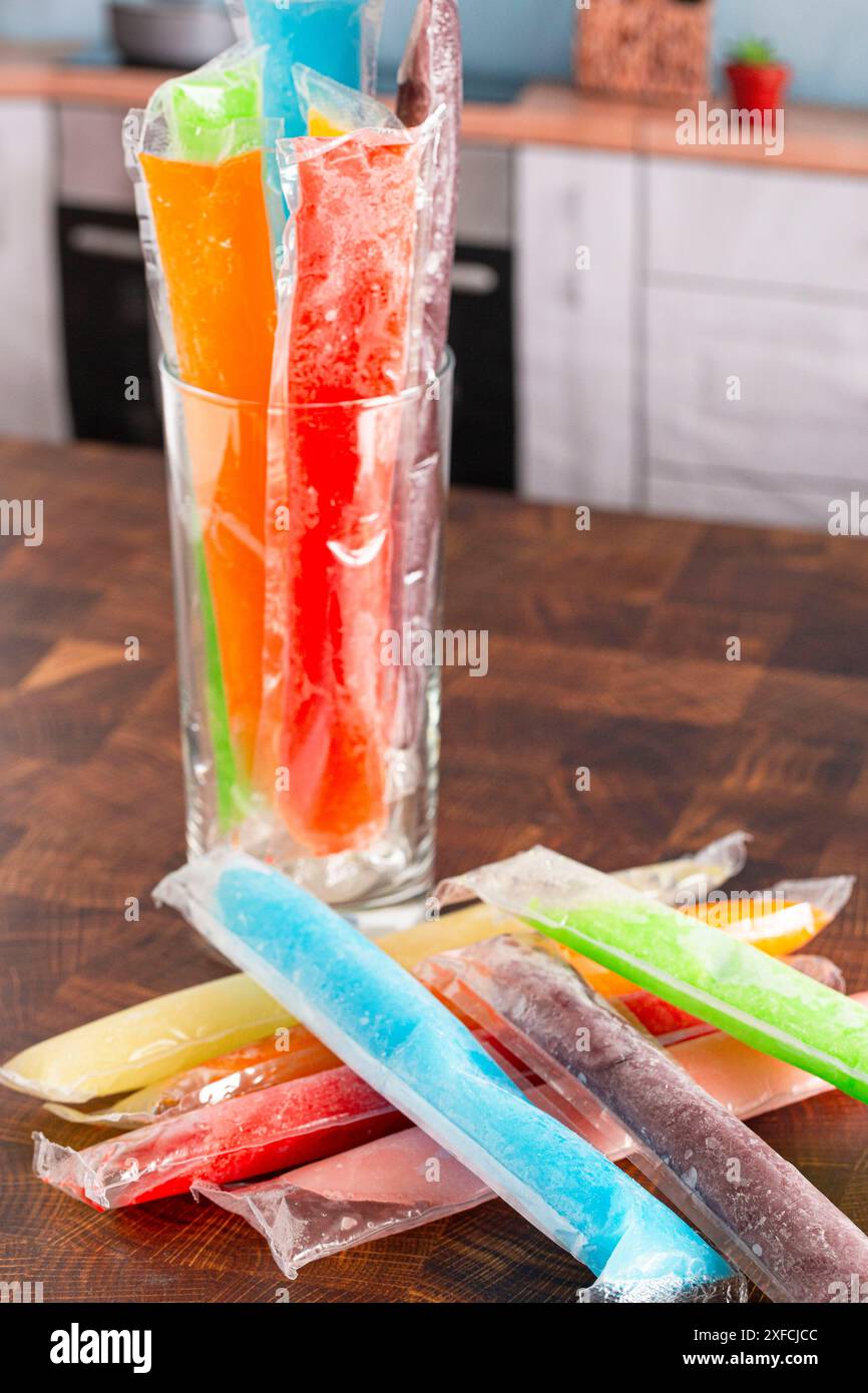 Succhietto di ghiaccio ghiacciato arcobaleno su un bancone da cucina Foto Stock