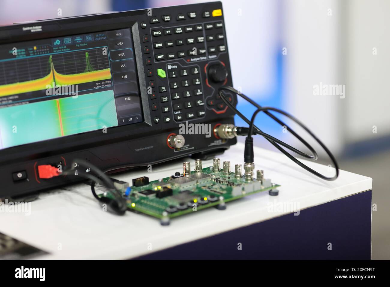 Test della scheda a circuito stampato da parte dell'analizzatore di spettro nel laboratorio di telecomunicazioni. Messa a fuoco selettiva. Foto Stock