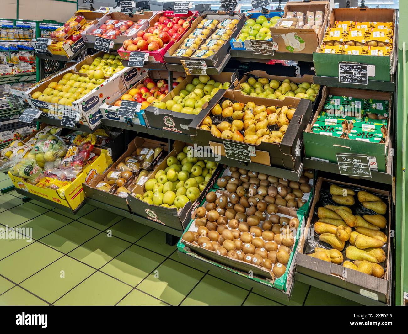 Italia - 02 luglio 2024: Mele, pere e kiwi in scatole esposte sullo scaffale del reparto fruttivendolo in vendita nel supermercato italiano Foto Stock