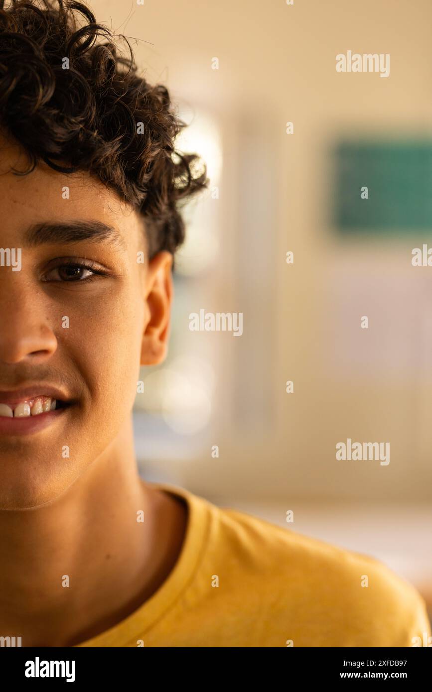 Adolescente sorridente al liceo, indossa una camicia gialla, guarda la macchina fotografica, copia spazio Foto Stock