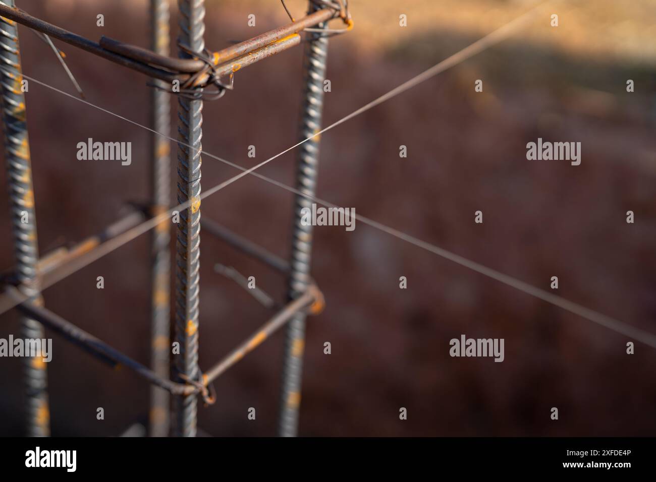 Armature per fondazioni in calcestruzzo in un cantiere. Barre in acciaio e struttura in ferro pronte per la fusione di calcestruzzo. Materiali e tecniche essenziali Foto Stock