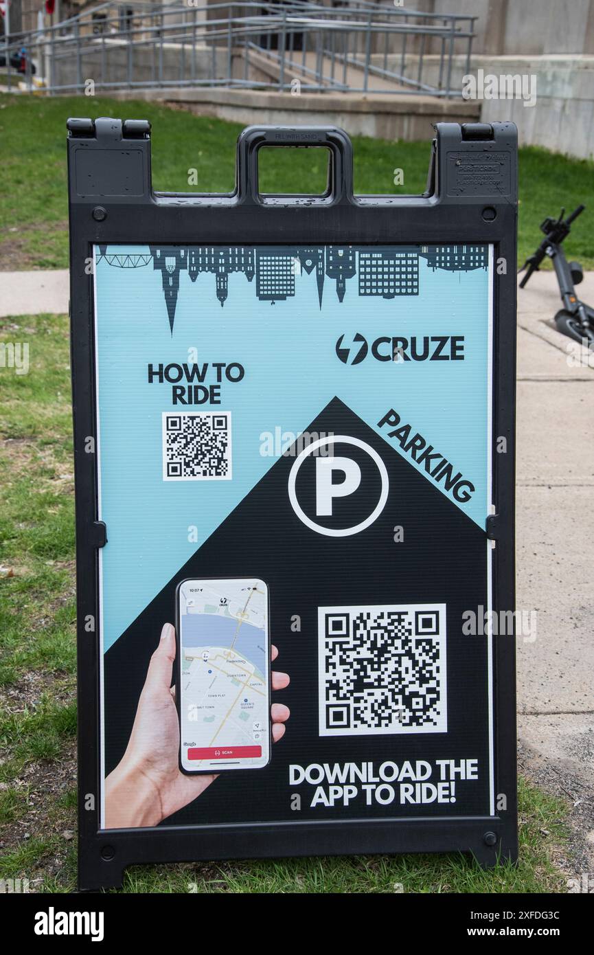 Insegna con istruzioni su come noleggiare e guidare uno scooter sul lungofiume sud nel centro di Fredericton, New Brunswick, Canada Foto Stock