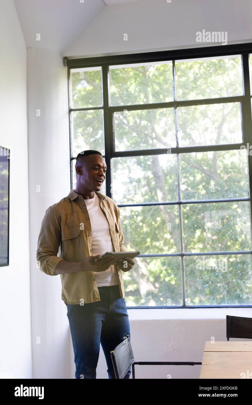 Presentazione di una proposta aziendale, uomo che tiene un tablet e parla durante una riunione d'ufficio, spazio per le copie Foto Stock