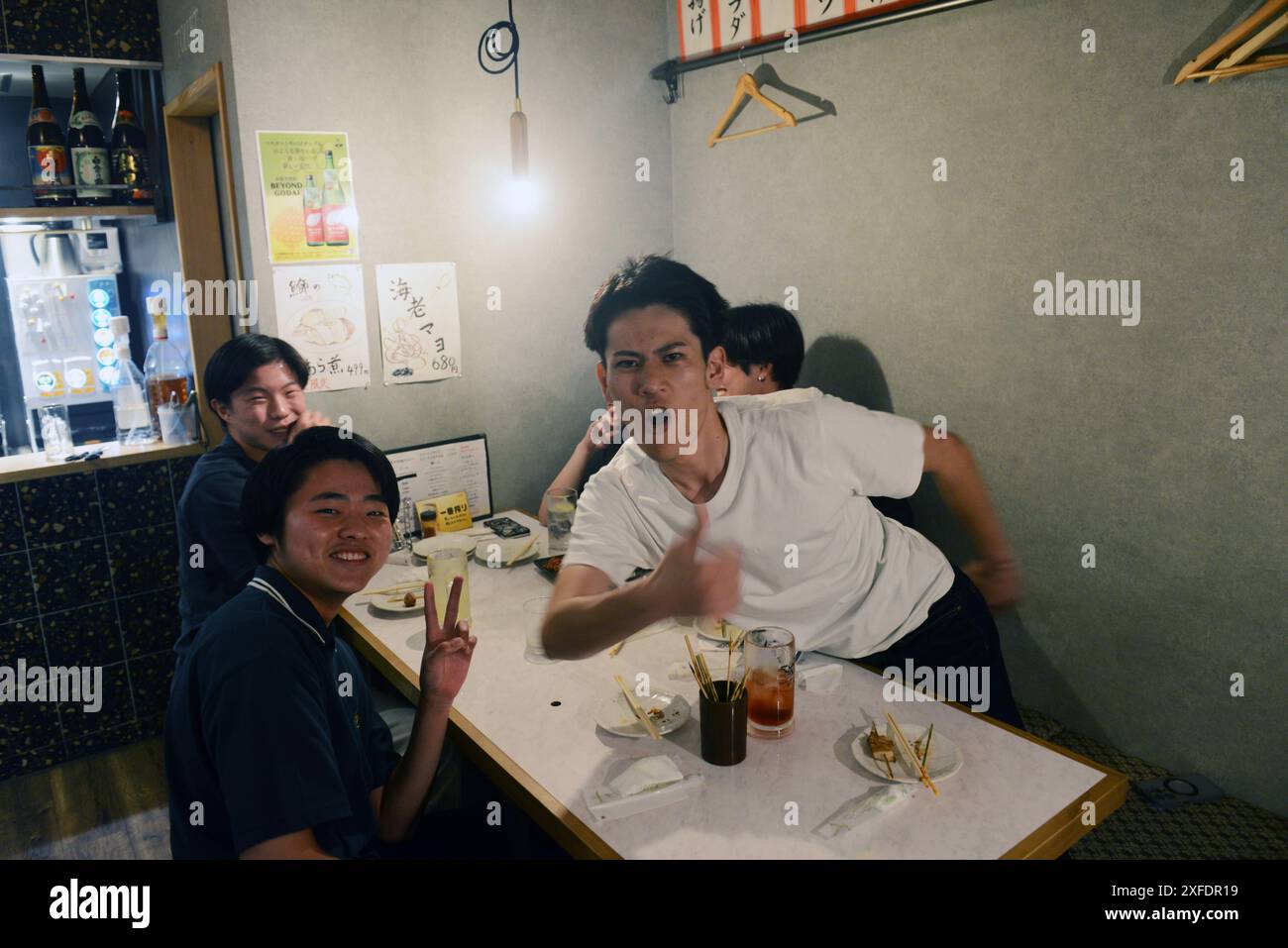 Giovani giapponesi si divertivano al ristorante Washio Yakitori a Kagoshima, Kyushu, Giappone. Foto Stock