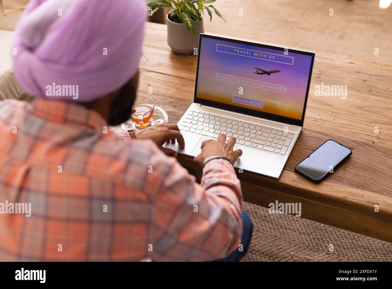 Prenotazione di viaggi online, uomo che utilizza un computer portatile con sito web di viaggi a casa Foto Stock