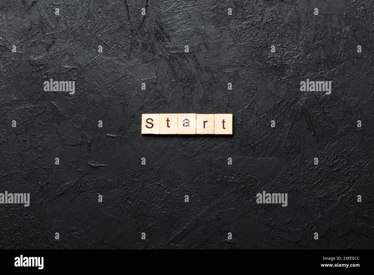 Parola di inizio scritta su blocco di legno. Testo di inizio sulla tabella di cemento per il vostro desing, concetto. Foto Stock
