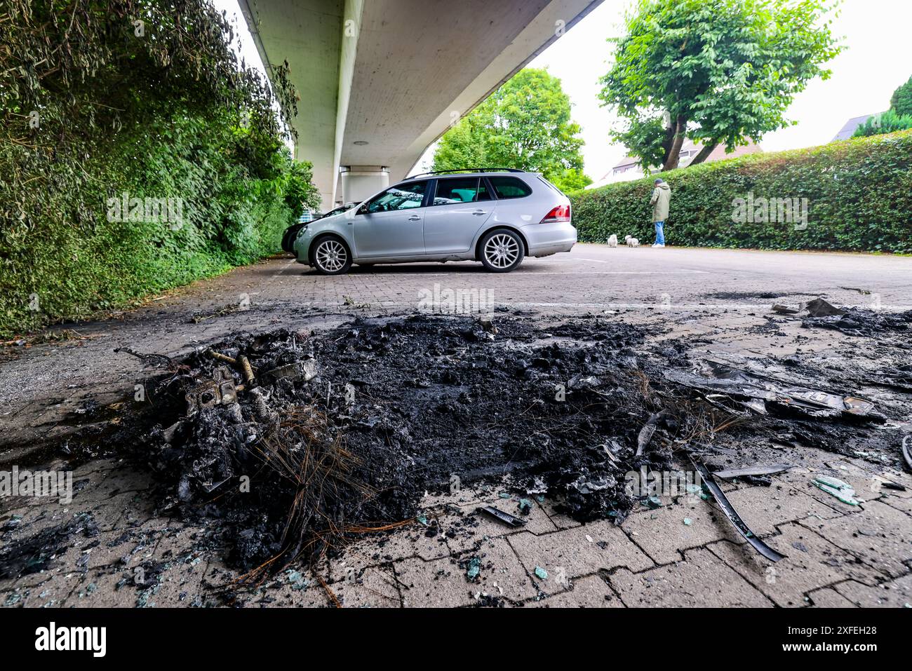 Duisburg, Germania. 3 luglio 2024. Resti di un incendio possono essere visti su Münchener Straße a Buchholz sotto il percorso della ferrovia leggera. Le auto bruciarono di nuovo nel sud di Duisburg durante la notte. Secondo un portavoce della polizia, non è ancora chiaro se ci sia un collegamento con l'auto spari la notte prima. Crediti: Christoph Reichwein/dpa/Alamy Live News Foto Stock