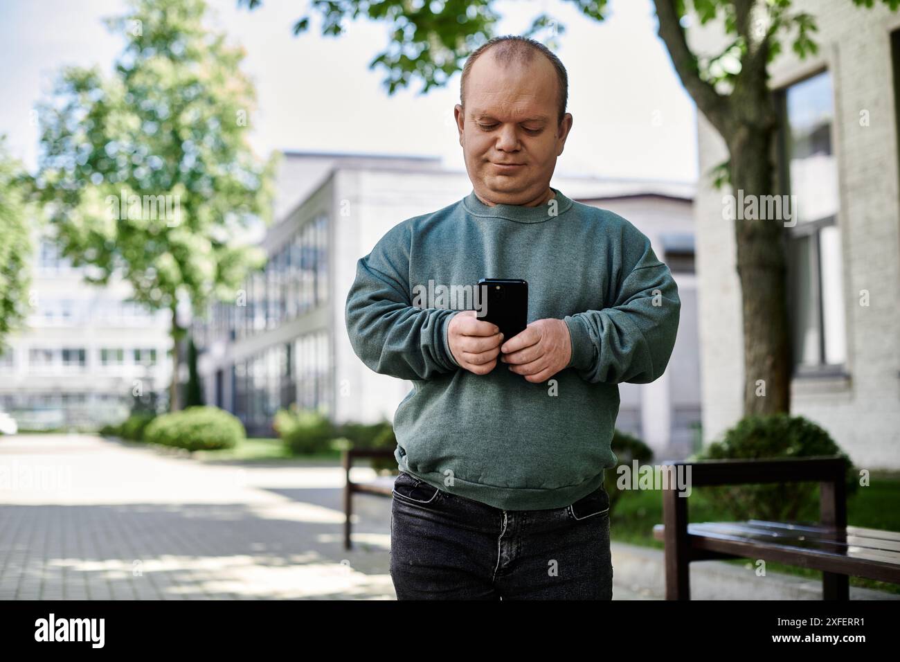 Un uomo con inclusività cammina per la città, usando il suo telefono. Foto Stock