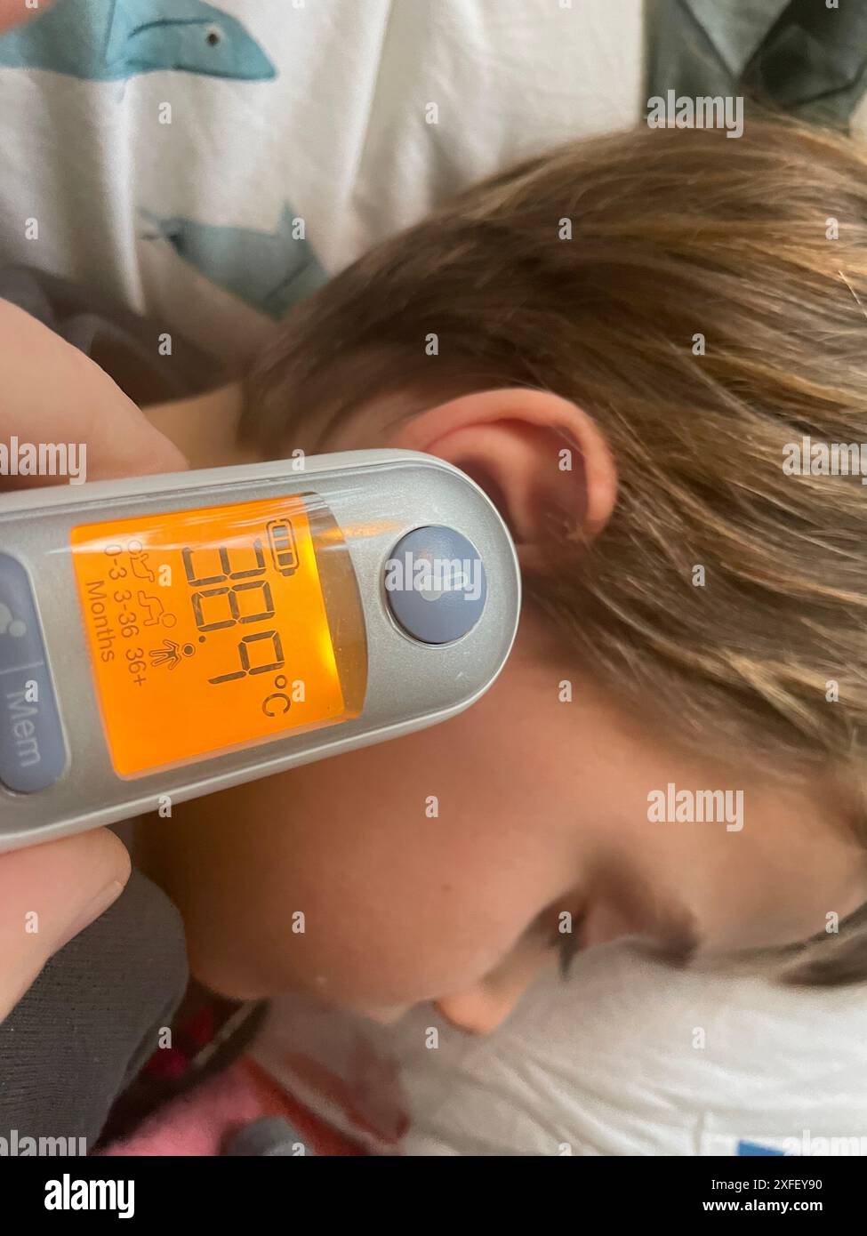 Paesi Bassi, il termometro per orecchie viene utilizzato per misurare la temperatura di un bambino malato. Foto Stock