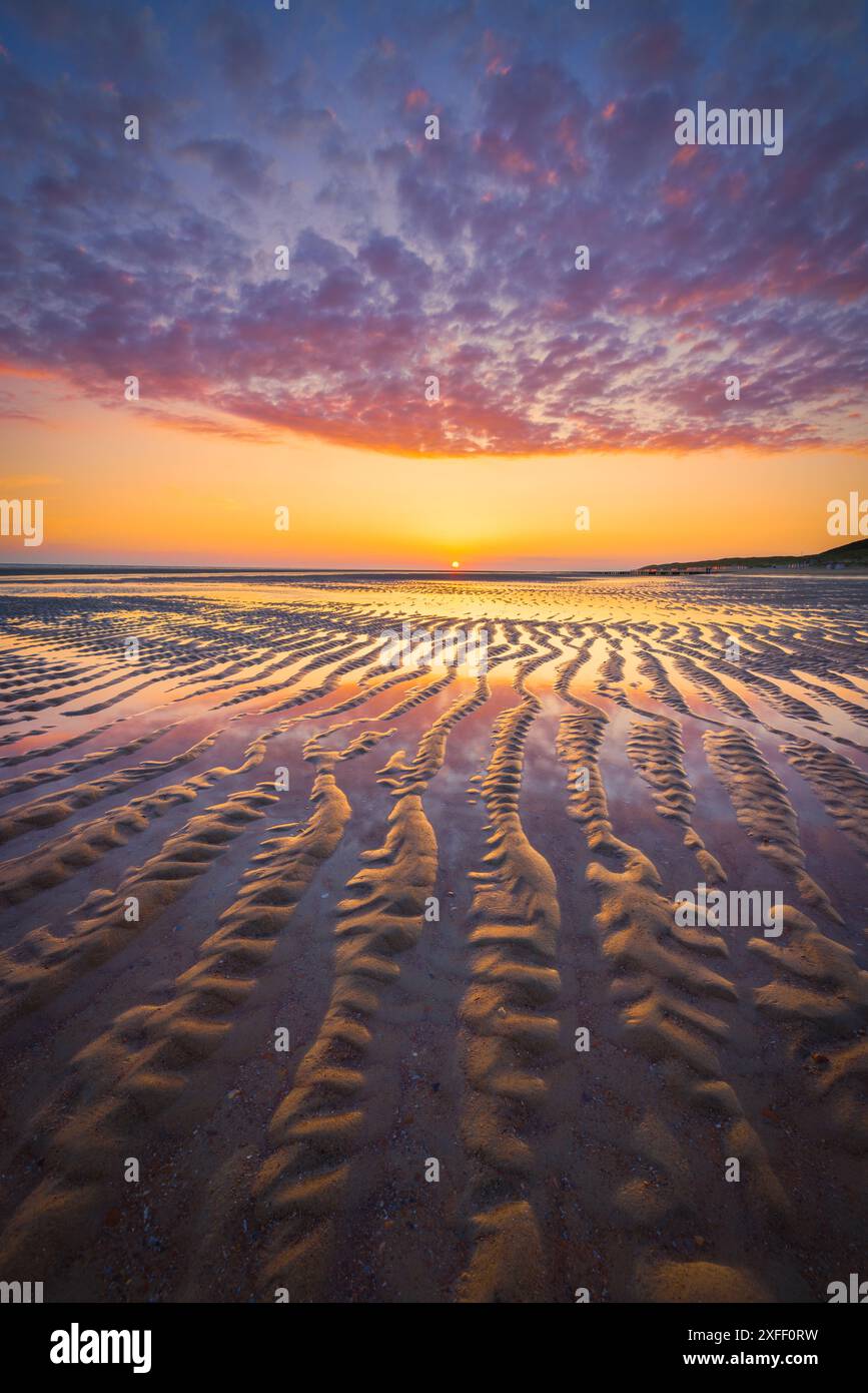 Una splendida immagine del mare sulla spiaggia vicino a Burgh-Haamstede con spettacolari colori vivaci e forti linee guida nella sabbia con riflessi. Foto Stock