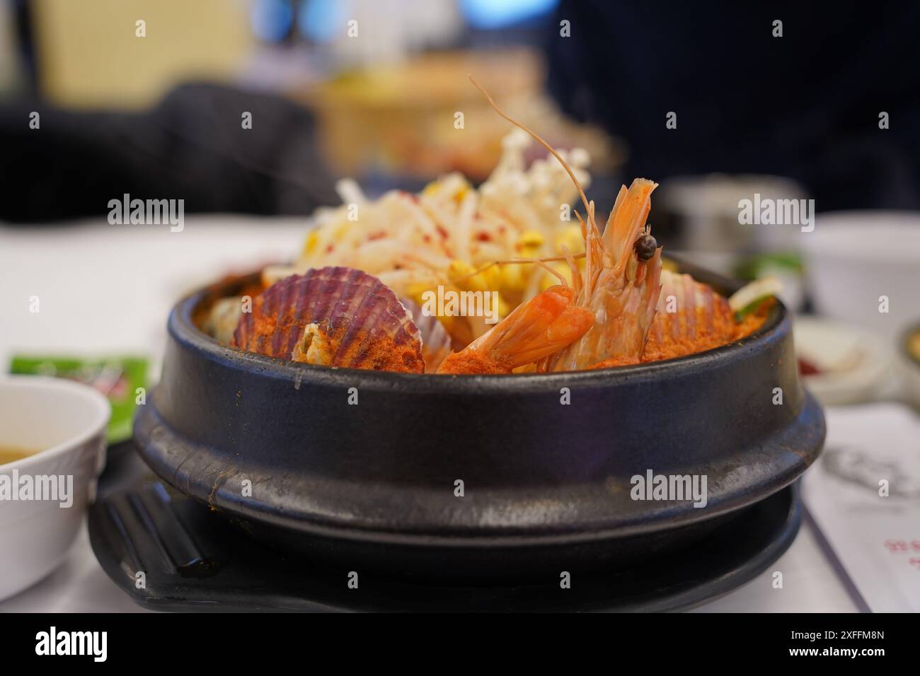 Stufato coreano preparato con pesce fresco come vongole e gamberi, margherite e funghi Foto Stock