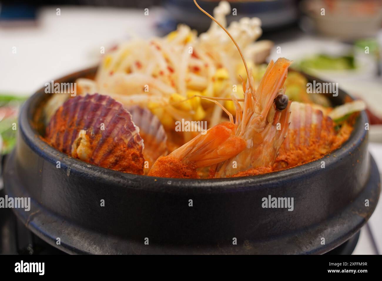 Stufato coreano preparato con pesce fresco come vongole e gamberi, margherite e funghi Foto Stock