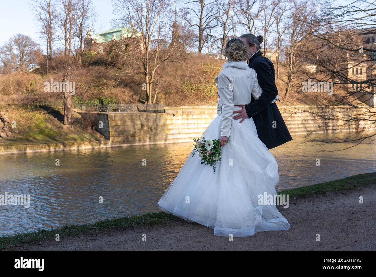 La sposa e lo sposo camminano vicino all'acqua, vista posteriore della coppia nuziale Foto Stock