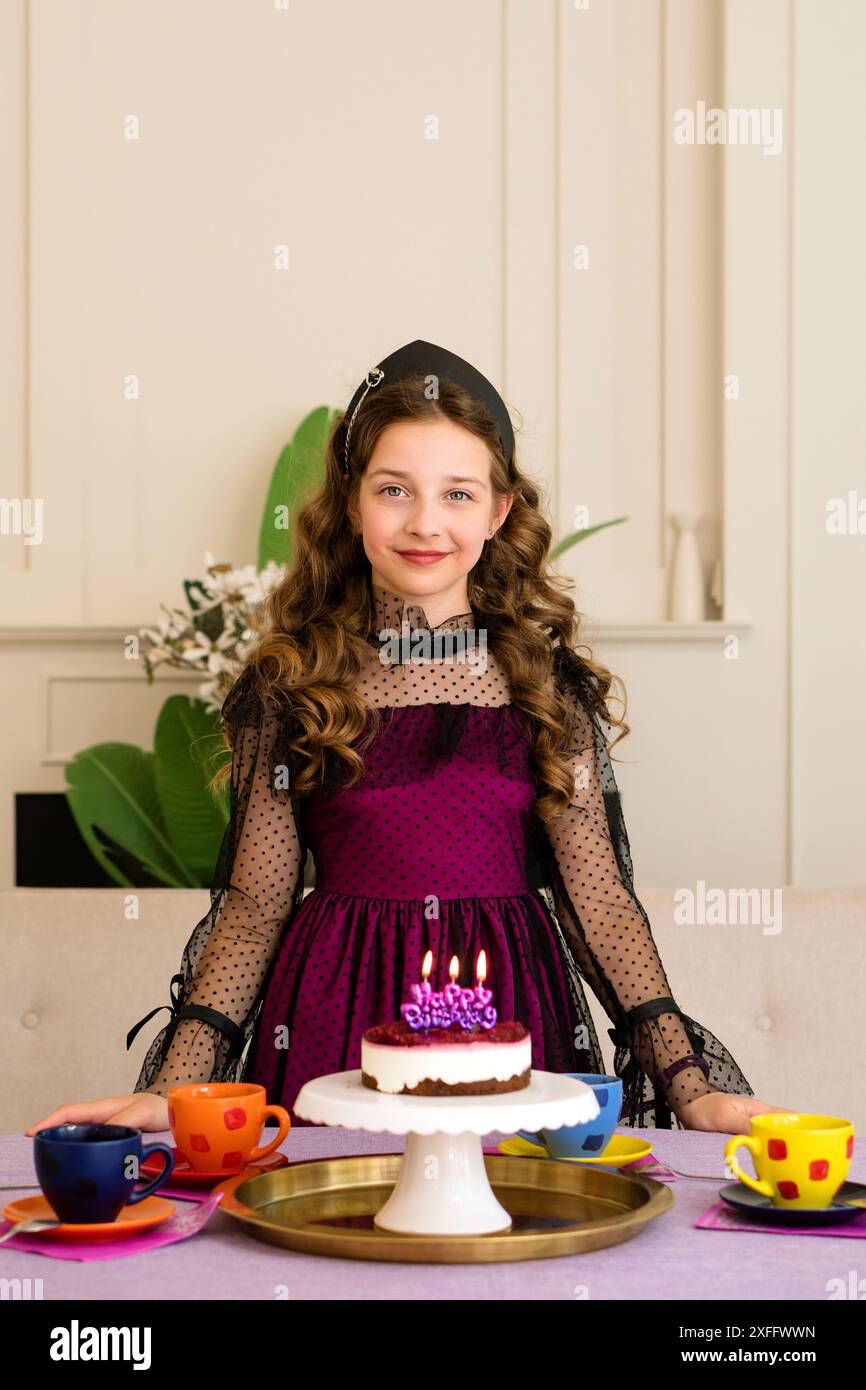 La ragazza con un abito elegante festeggia il compleanno con una torta. Ritratto di una bella ragazza di compleanno Foto Stock