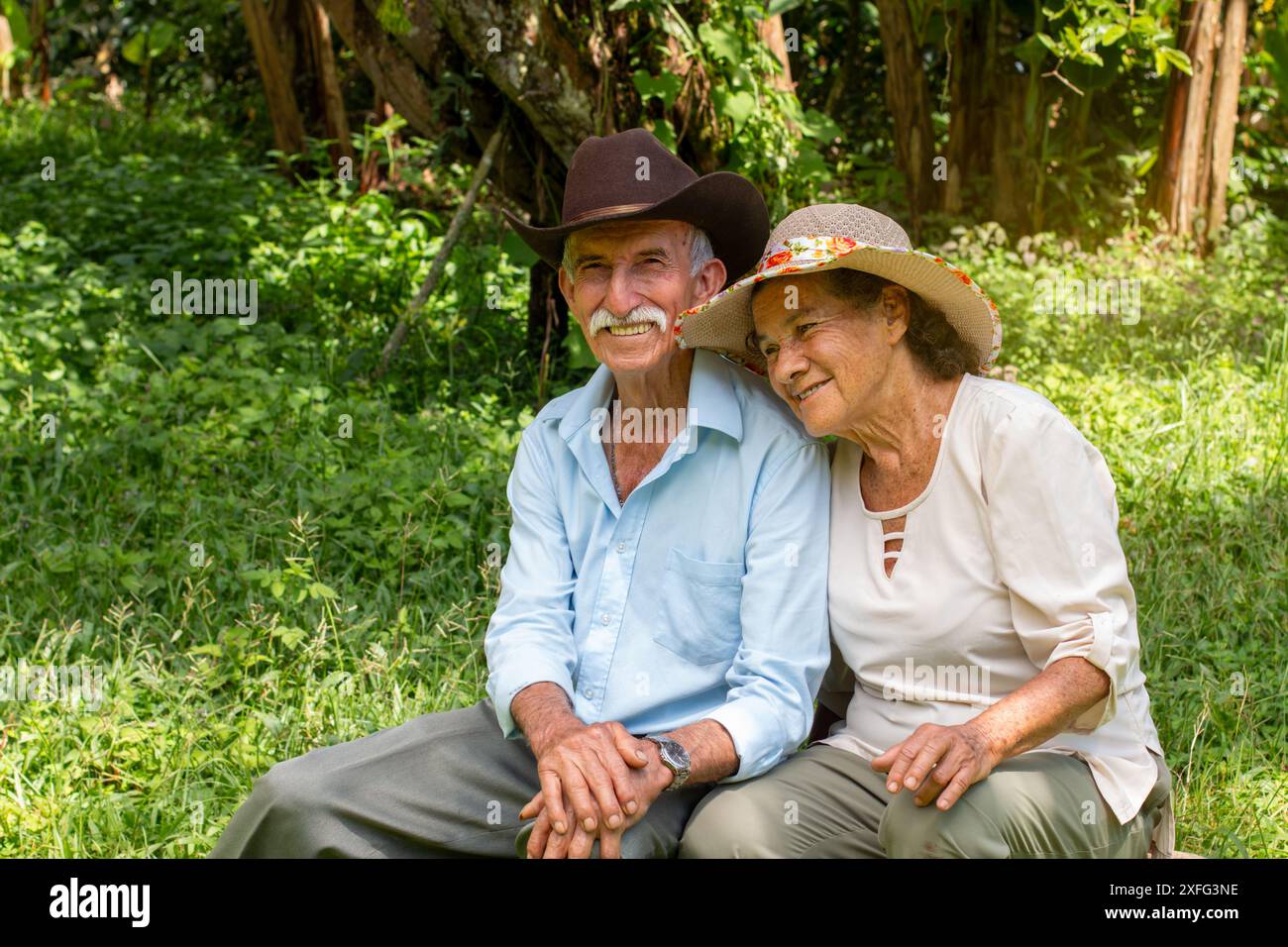 Stile di vita: Coppia di sposi anziani sorridenti seduti all'aperto Foto Stock