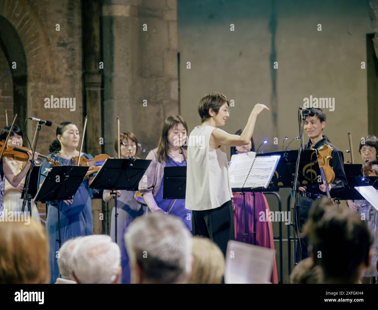 Cremona, Italia - 28 giugno 2024 Cremona Summer Festival Ensemble Miyaji, direttore d'orchestra femminile, è in gesto mentre guida il suo team di musicisti Foto Stock