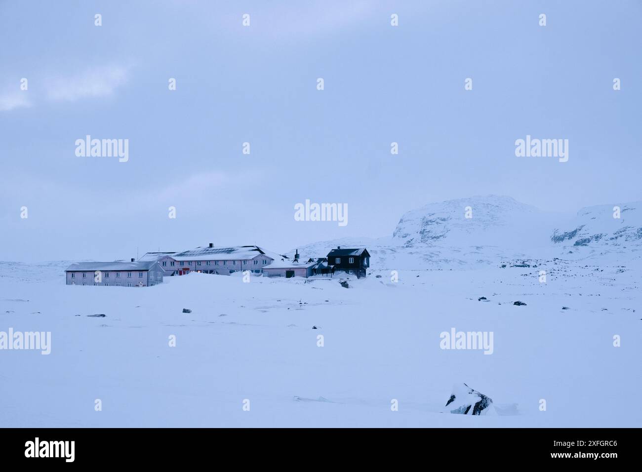 Finse, Norvegia -- DNT Finsehytta in una fredda serata di gennaio, vista dall'altro lato del lago Finse (Finsevatnet) Foto Stock