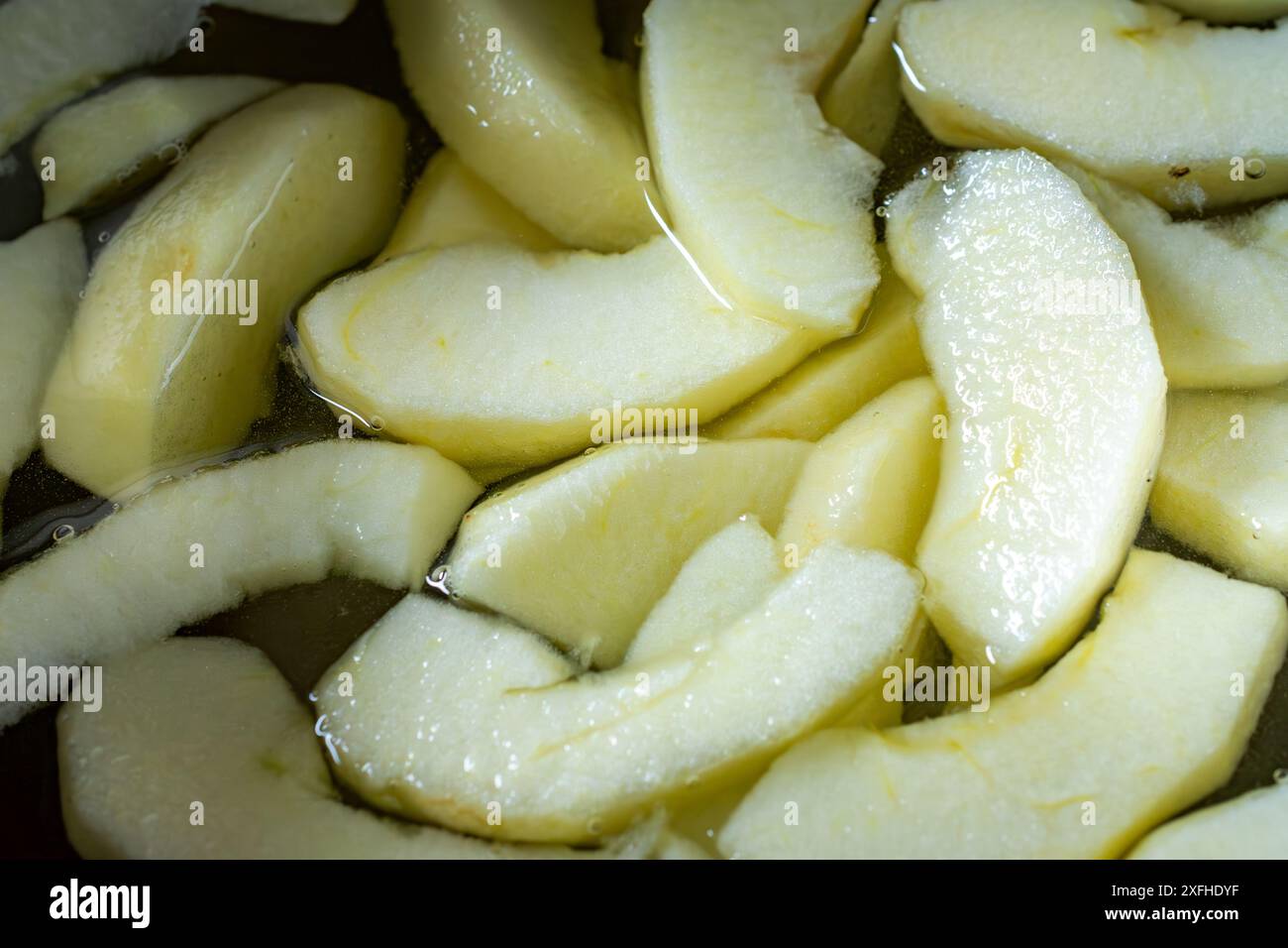 Vista ravvicinata delle fette di mela di gala in acqua salata. Preparazione per una torta. Foto Stock