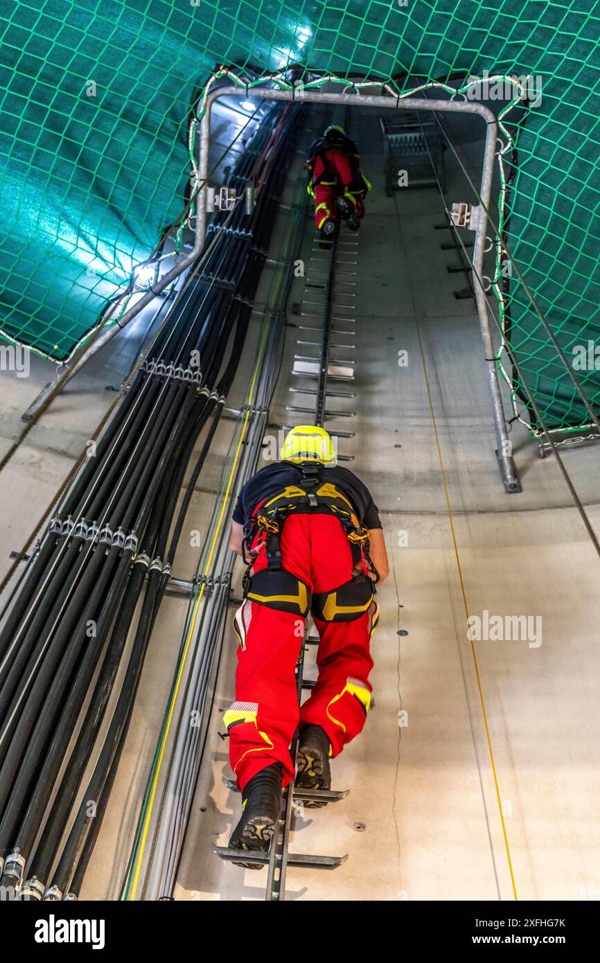 I soccorritori in altezza dei vigili del fuoco professionisti di Oberhausen praticano la discesa da una turbina eolica da un'altezza di 150 metri, salendo fino alla t Foto Stock