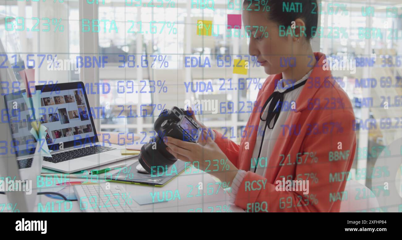 Immagine del tabellone di negoziazione e del modello a griglia, donna asiatica che trasferisce le foto dalla fotocamera al laptop Foto Stock