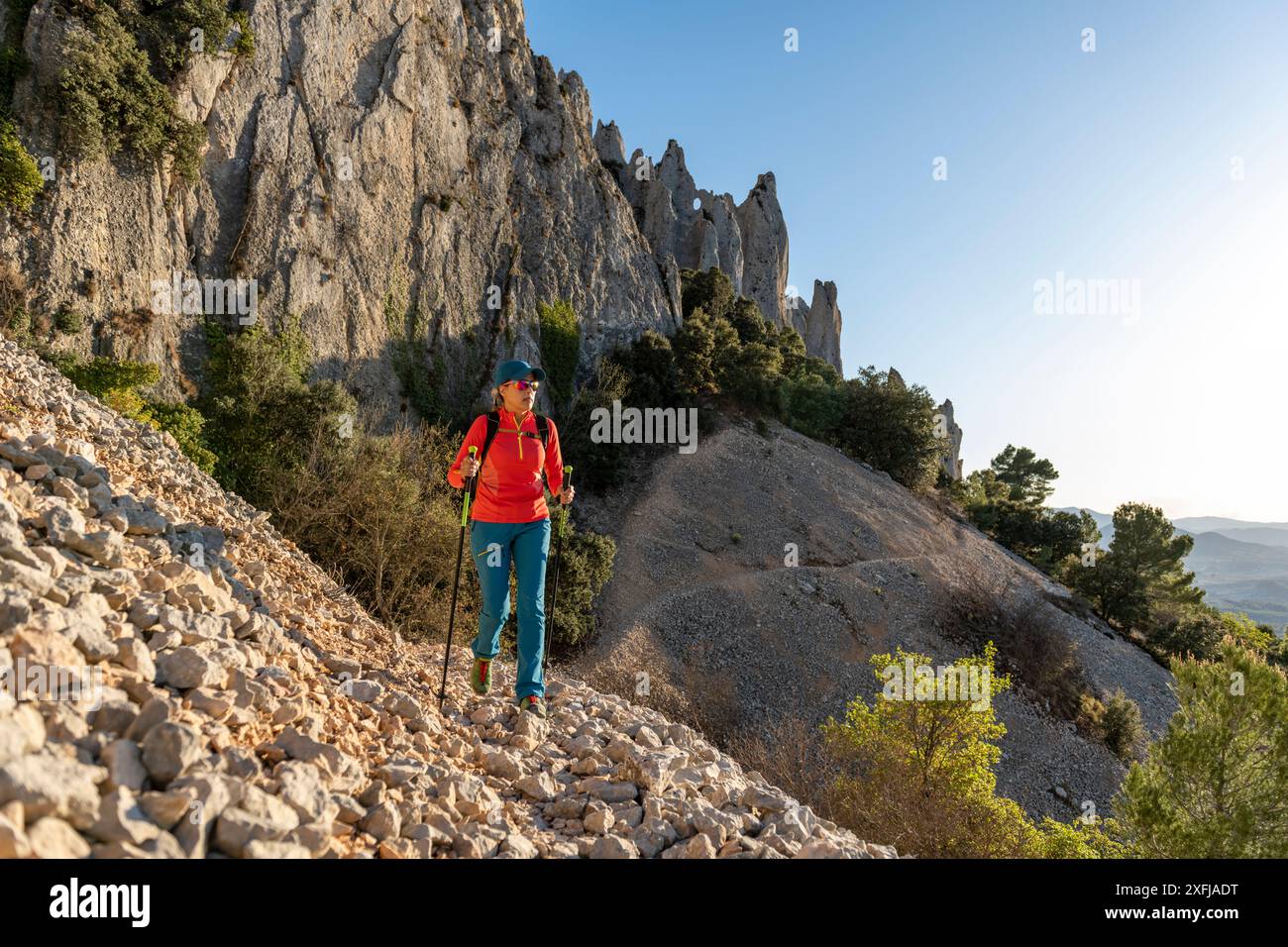 Donna backpacker sul sentiero escursionistico per la catena montuosa Frares de Serrella in Costa Blanca, Quatretondeta , Alicante, Spagna - foto stock Foto Stock