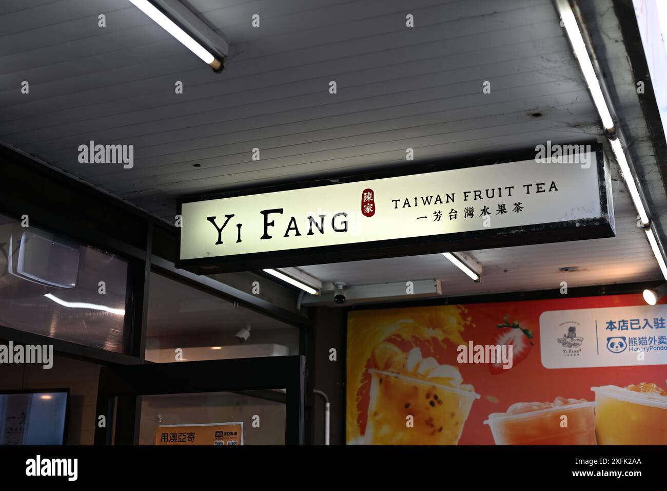 Insegna illuminata del tè alla frutta Yi Fang Taiwan appesa al tendalino sopra l'ingresso del negozio di tè Foto Stock