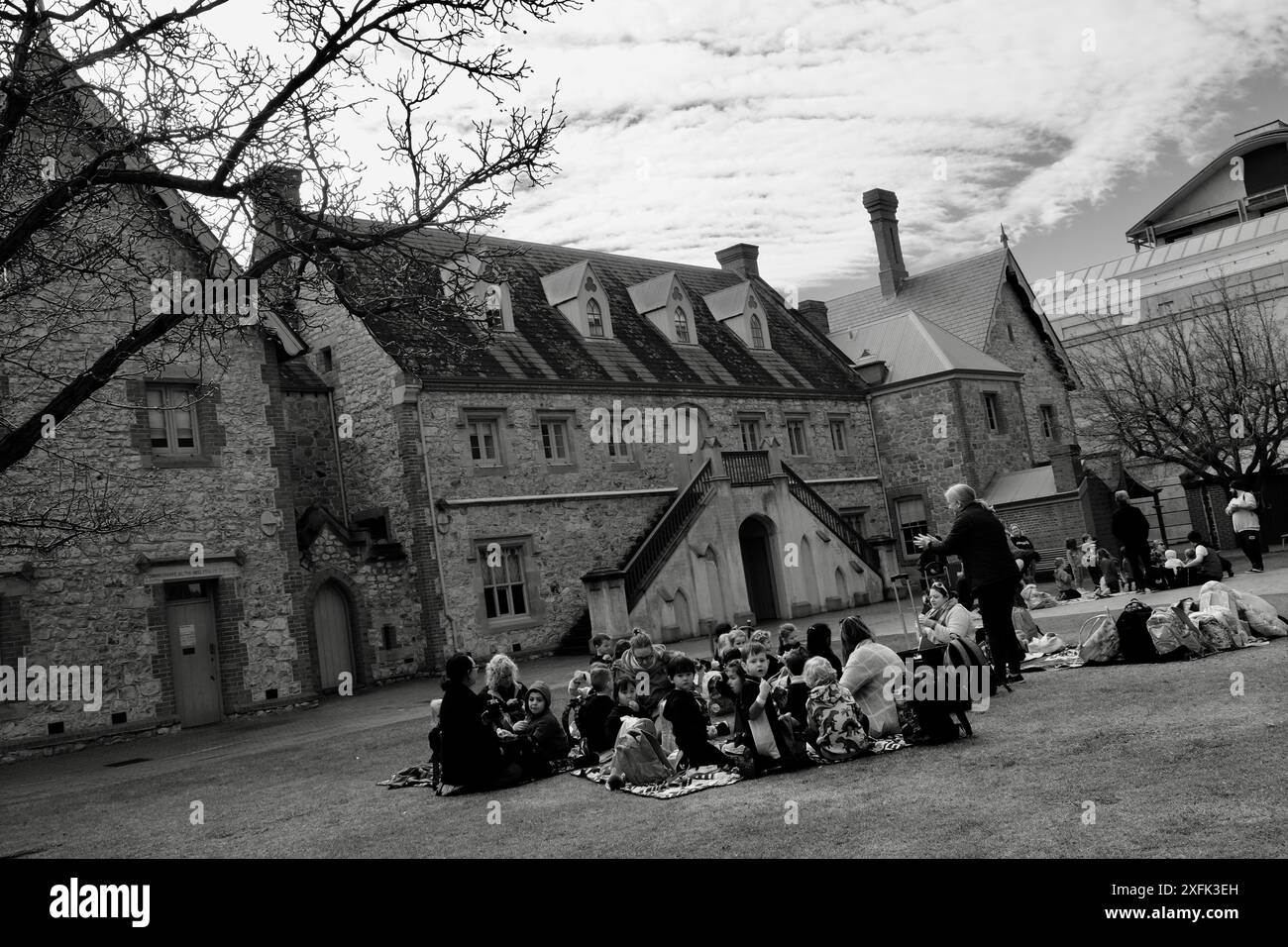 Gli insegnanti portano gruppi di bambini all'attività scolastica in giardino in una giornata di sole Foto Stock