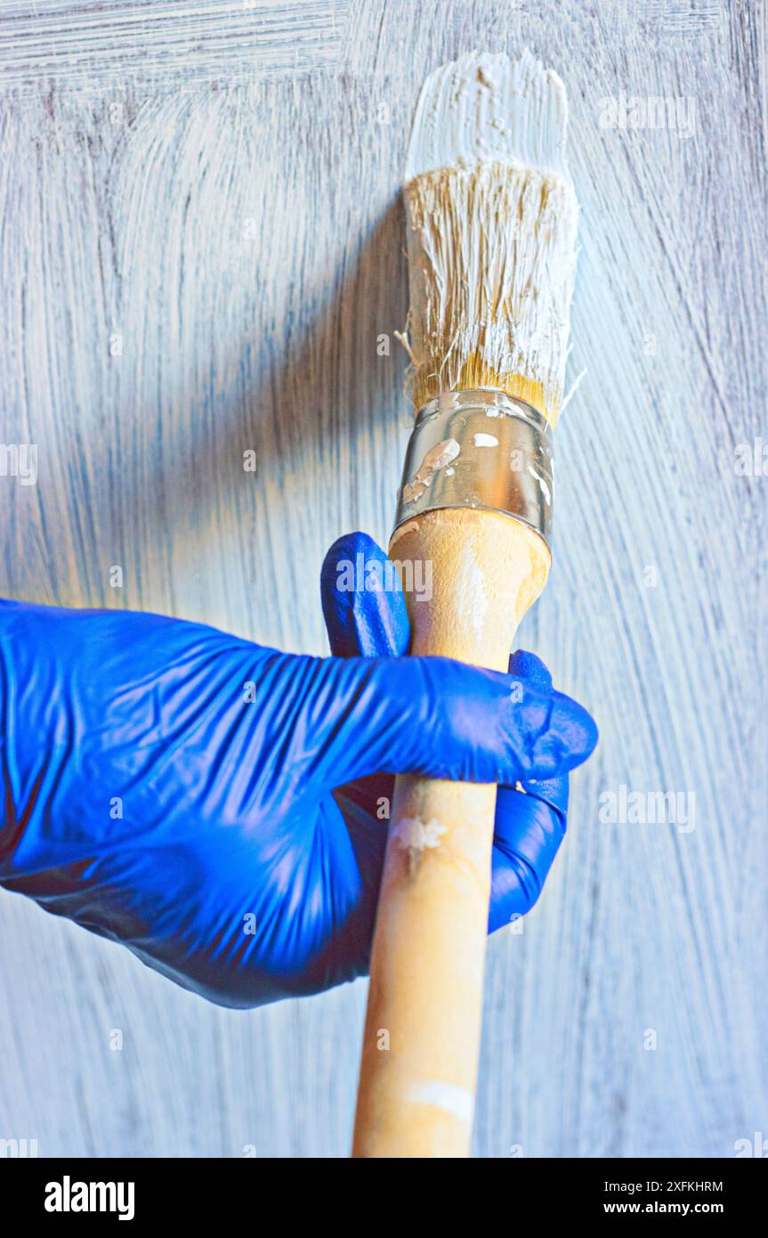 Dipingendo un vecchio pezzo di arredamento bianco da ristrutturare. Foto Stock