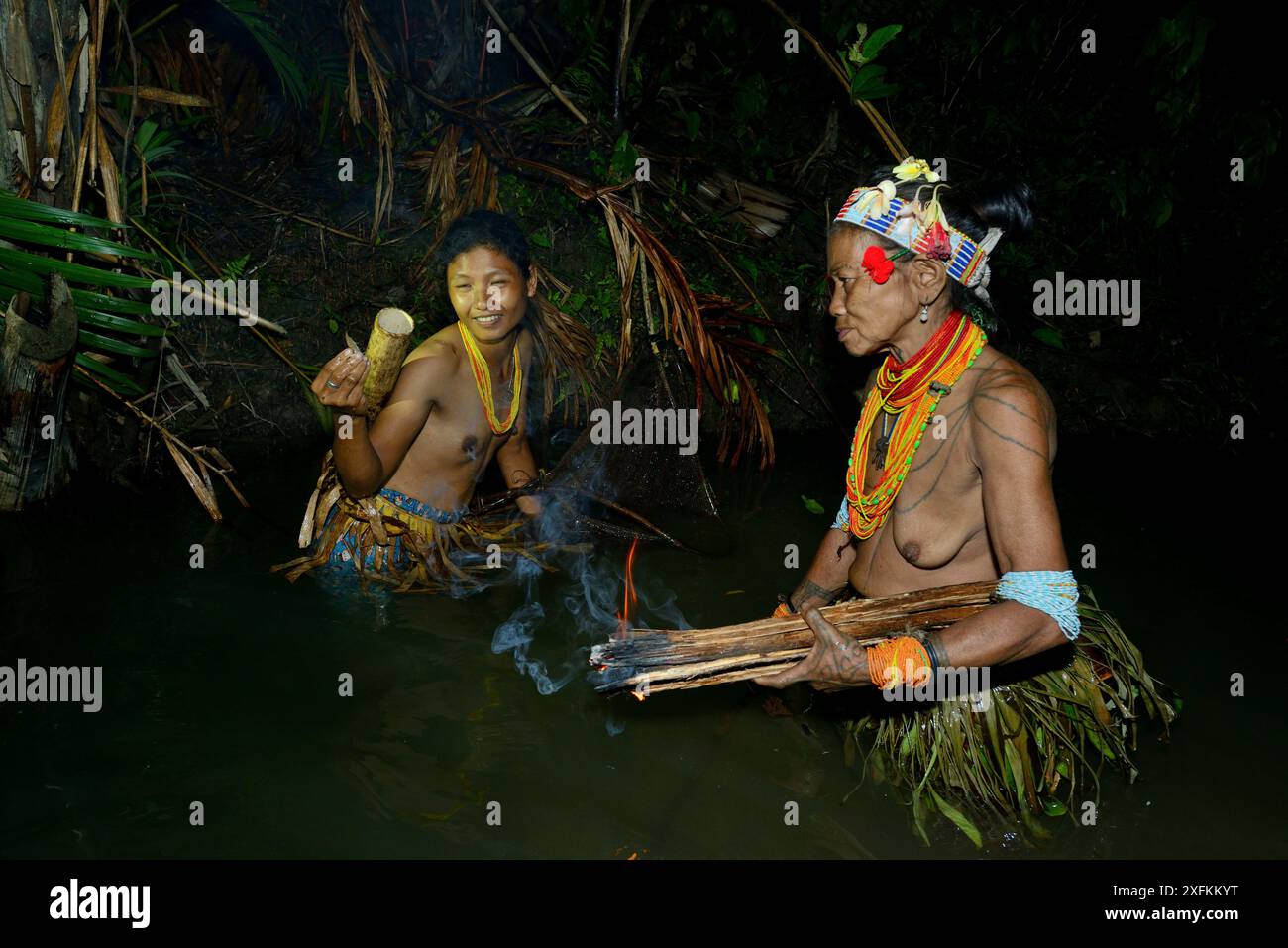 Donne Mentawai che pescano di notte, usando legna da fuoco per la luce per attirare i pesci, Siberut, Sumatra, luglio 2015 Foto Stock