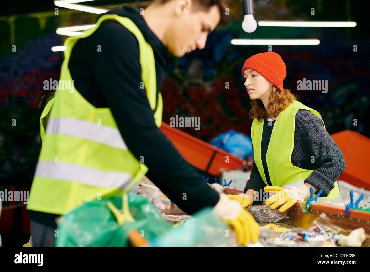 i volontari eco-attenti raccolgono i rifiuti in gilet gialli e guanti. Foto Stock