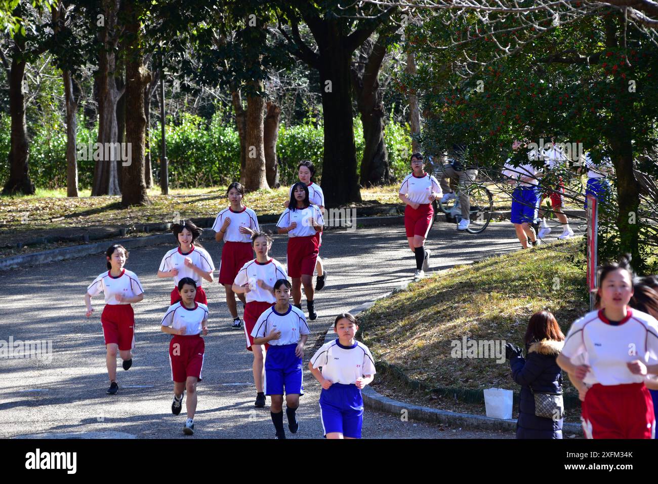 Studenti delle scuole superiori giapponesi in palestra che fanno jogging nel parco del castello di Osaka durante un evento di corsa scolastica Foto Stock