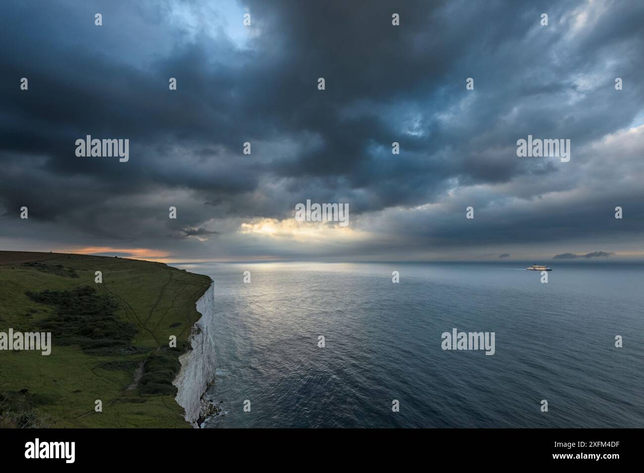 Tempesta di ritorno sulle bianche scogliere di dover con traghetto che attraversa il canale. Kent, Regno Unito. Luglio Foto Stock