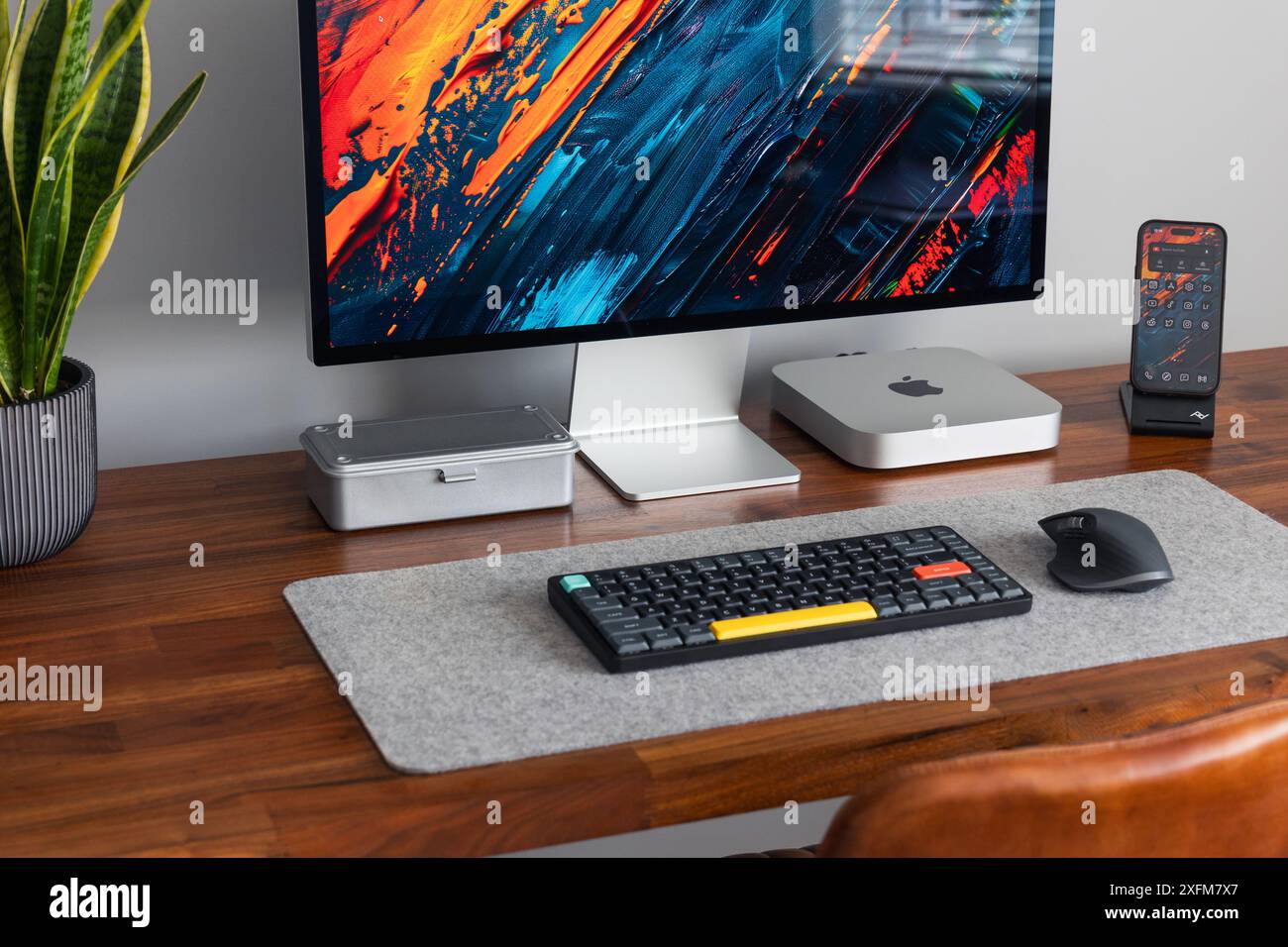 LONDRA - 26 GIUGNO 2024: Computer Apple Mac in un moderno ufficio domestico, lavoro da casa configurazione minima della scrivania Foto Stock