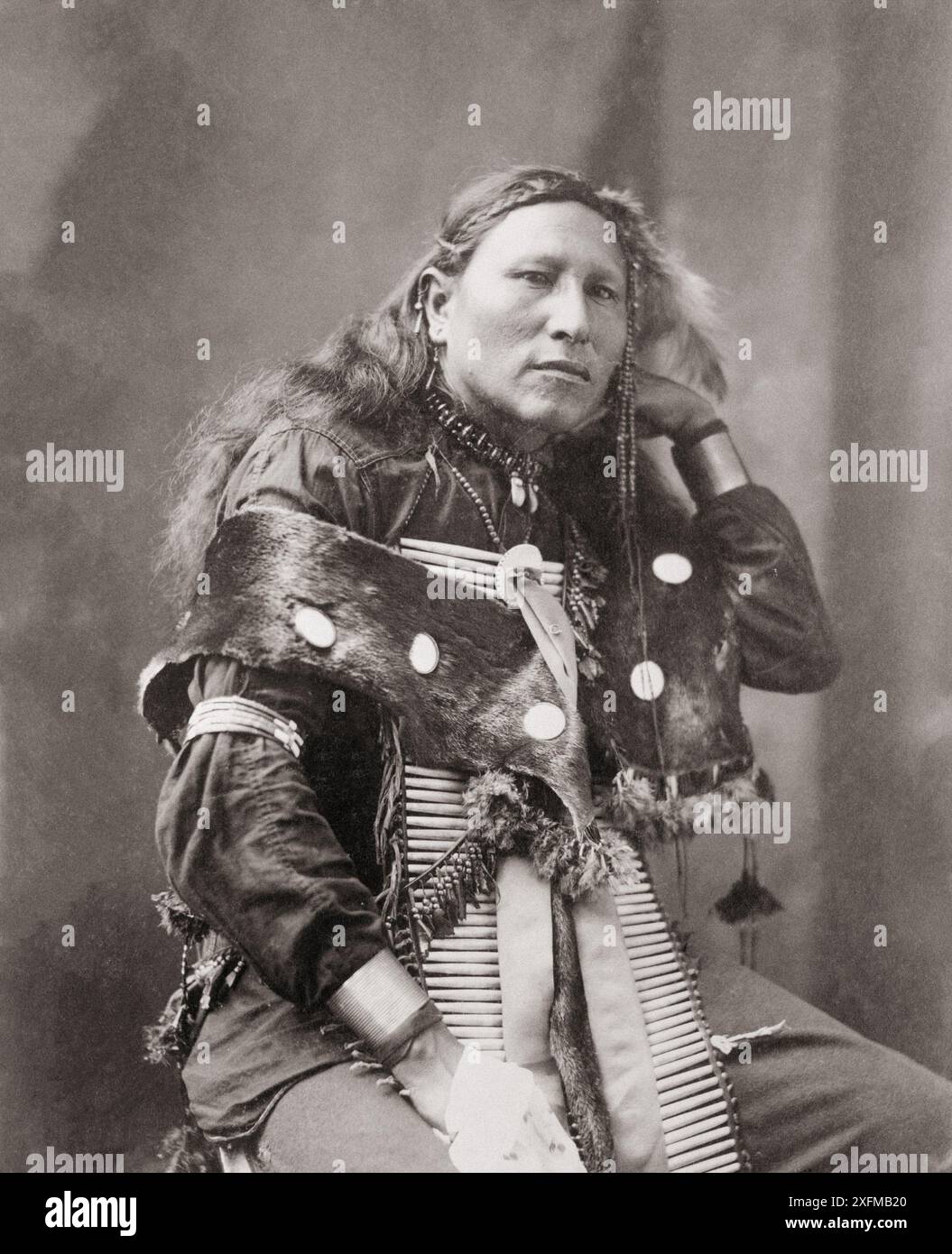 Foto d'epoca di Little Eagle, indiano, ritratto di tre quarti di lunghezza, seduta, rivolta a destra. STATI UNITI, 1900 Foto Stock