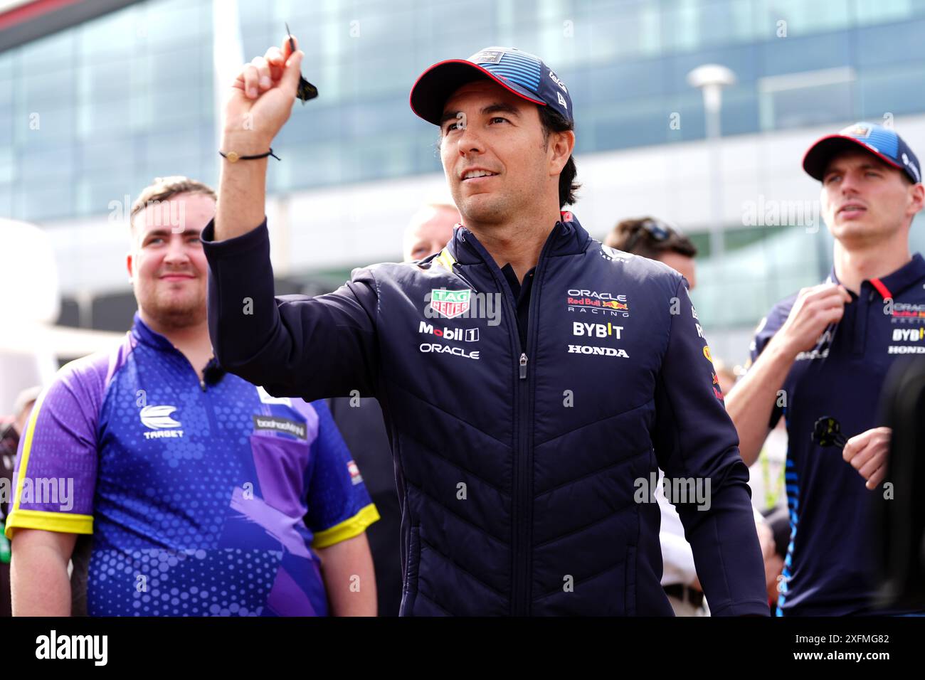 Sergio Perez della Red Bull Racing che gioca a freccette con Luke Littler (a sinistra) e Max Verstappen della Red Bull Racing (a destra) al circuito di Silverstone, Northamptonshire. Data foto: Giovedì 4 luglio 2024. Foto Stock