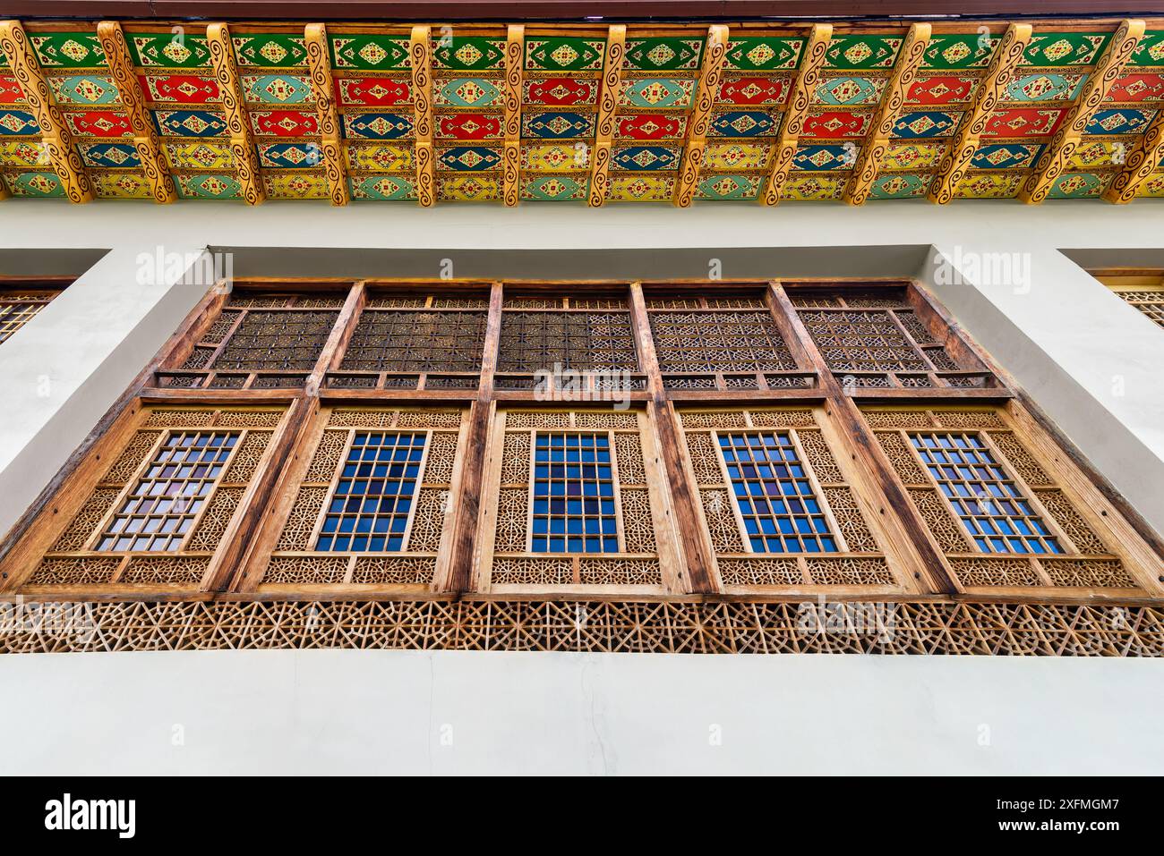 Intricate finestre in legno presso il Palazzo Shakikhanovs a Shaki, Azerbaigian, sono incorniciate da un soffitto colorato Foto Stock
