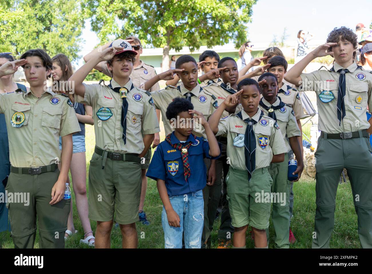 Austin, Texas USA, 4 luglio 2024. I membri di una truppa Boy Scout più un saluto Cub Scout mentre recitavano il Pledge of Allegiance agli Stati Uniti durante la parata annuale del quartiere di Barton Hills del 4 luglio. Alcune centinaia di residenti hanno percorso la parata di 1/2 km fino alla scuola elementare e hanno gustato biscotti, anguria e gelato. Crediti: Bob Daemmrich/Alamy Live News Foto Stock