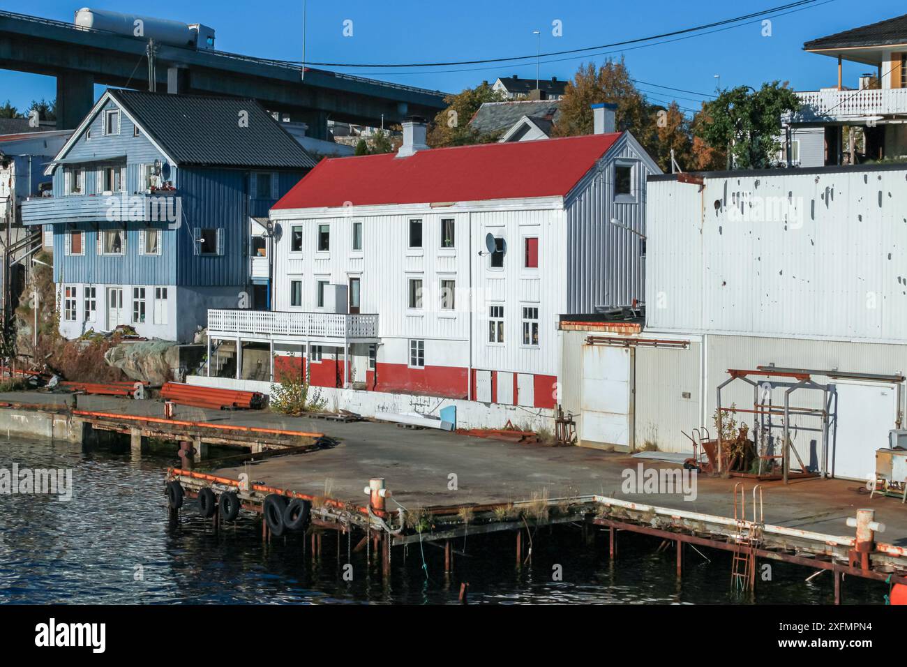 Vista sul mare di Kristiansund con vecchi fienili in legno vicino al ponte, paesaggio costiero norvegese Foto Stock