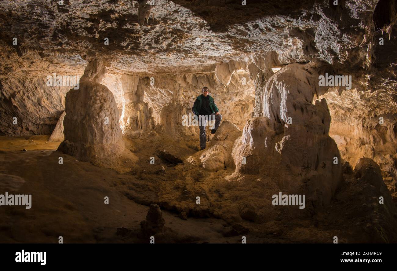 Uomo in posa tra le colonne rocciose della grotta di Molino de Aso, Parco Nazionale di Ordesa (Parco Nazionale IUCN categoria II), Pirenei, Spagna, ottobre 2013. Foto Stock