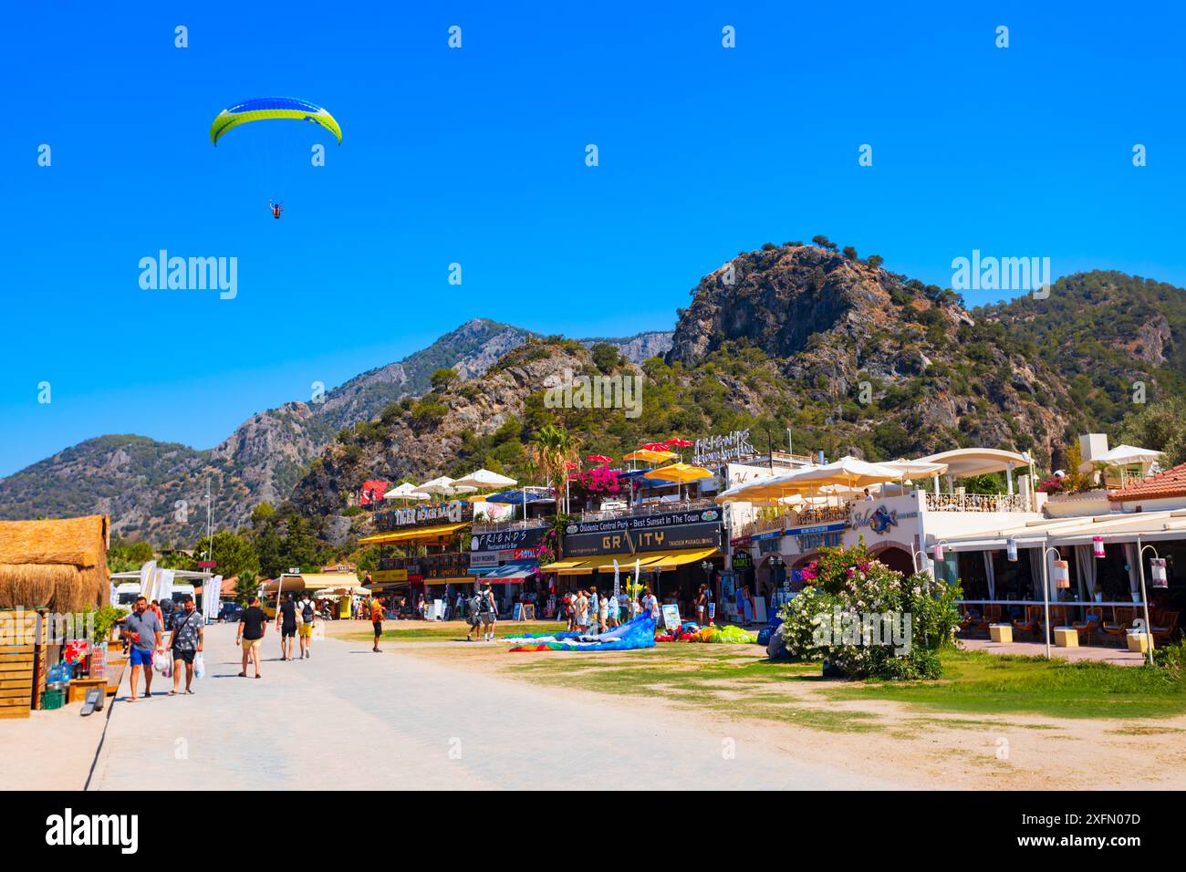 Oludeniz, Turchia - 13 luglio 2022: Volo in parapendio al centro di Oludeniz o spiaggia della Laguna Blu nel distretto di Fethiye nella provincia di Mugla, Turchia. Foto Stock