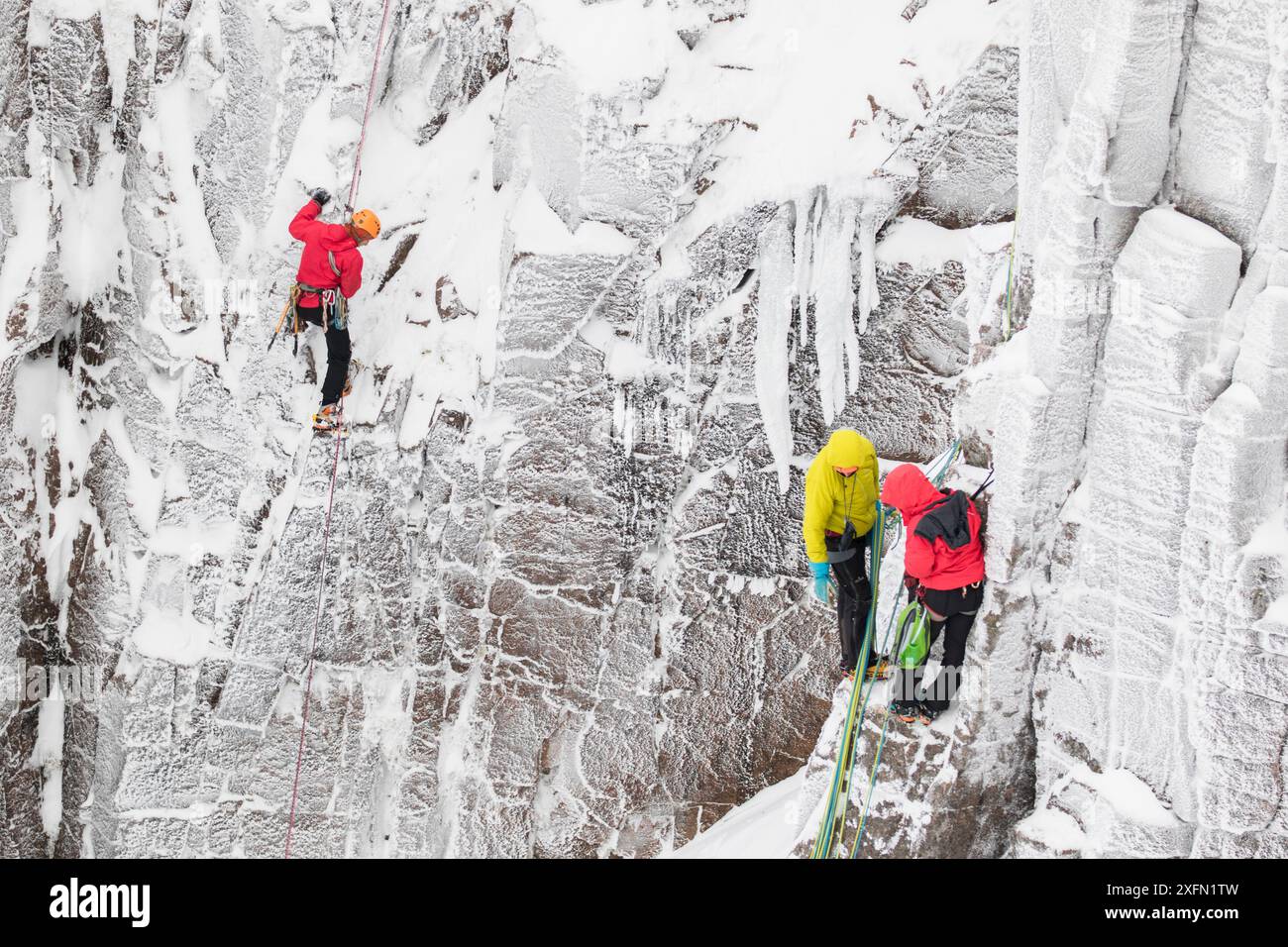 Arrampicatori sulla parete rocciosa verticale in inverno, Northern Corries, Cairngorms National Park, Scozia, Regno Unito, dicembre 2015. Foto Stock