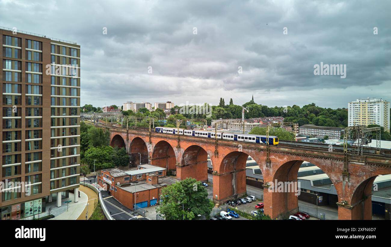 Viadotto di Stockport con un treno locale per pendolari del nord che passa sopra Foto Stock