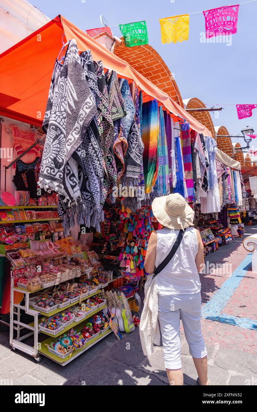 Mercato del Messico; donna turistica che fa shopping in un colorato bancone nel mercato all'aperto dell'artigianato di El Parian, Puebla, Messico. Foto Stock