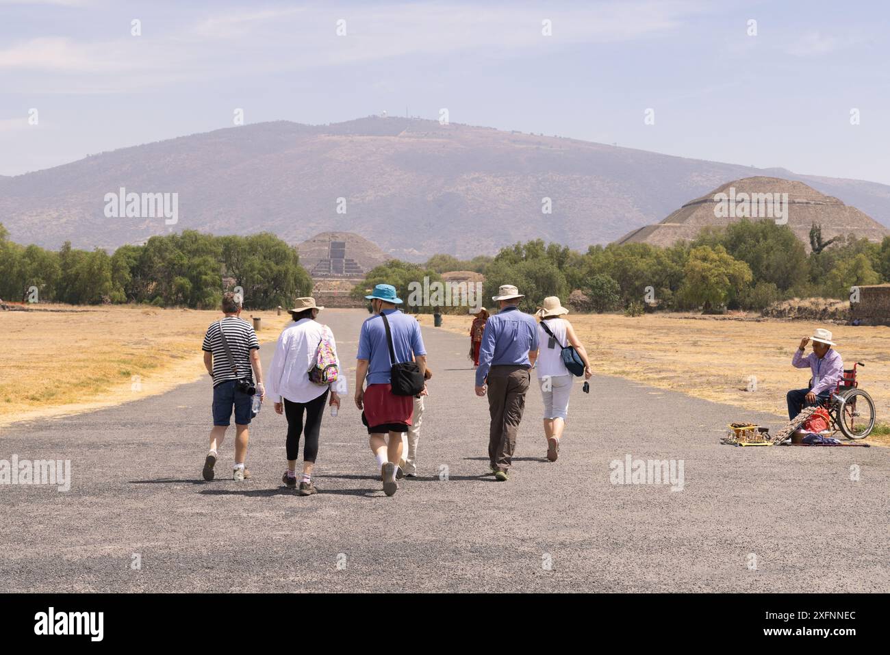 Gente che cammina per il viale dei morti, Teotihuacan, Messico. Sito mesoamerica precolombiano, 200BC-750AD. Piramide del Sole sullo sfondo Foto Stock